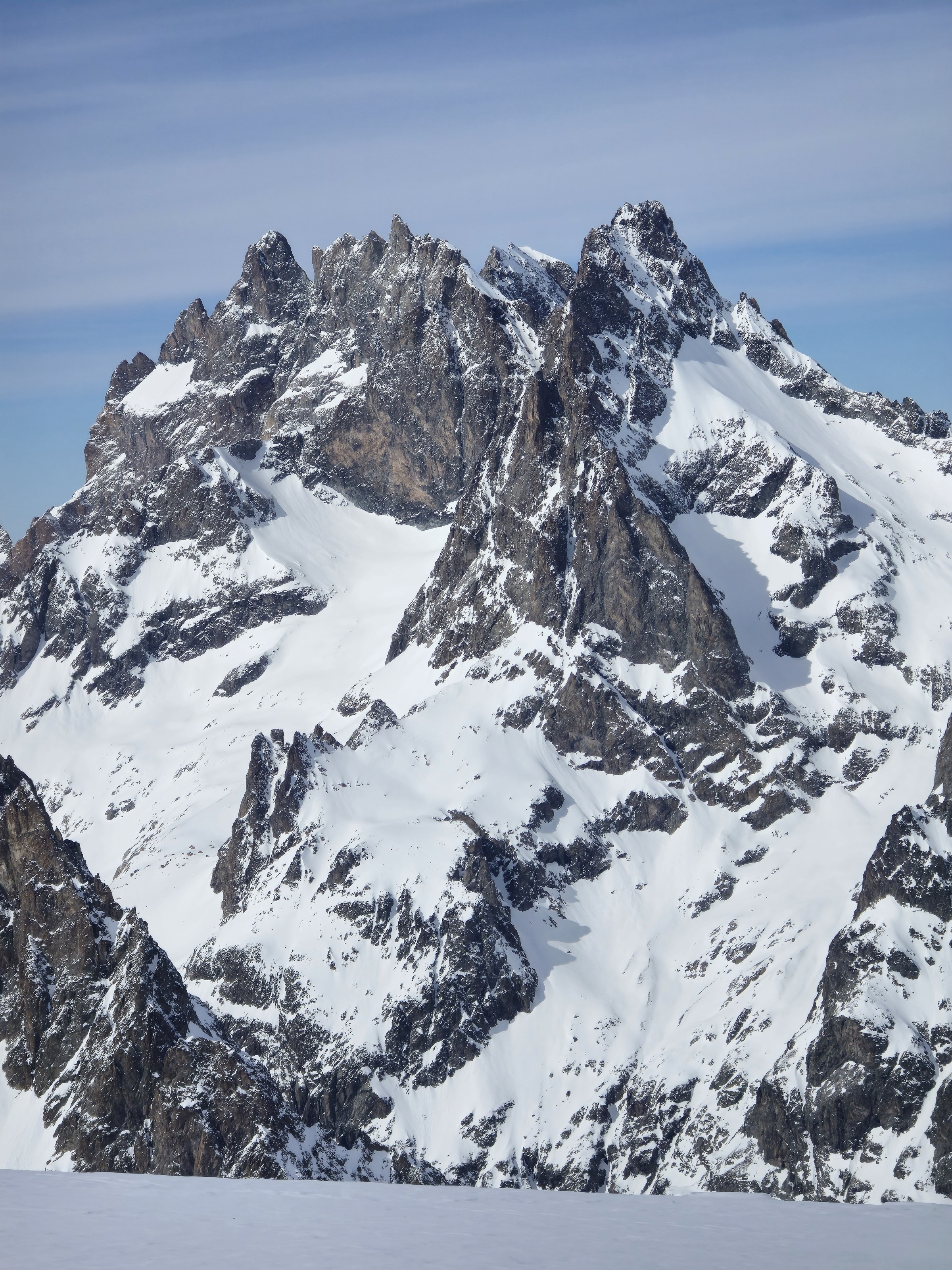 Sommet rocheux aux arêtes déchiquetées, couvert de neige, vu pendant le Tour des Agneaux (Écrins)