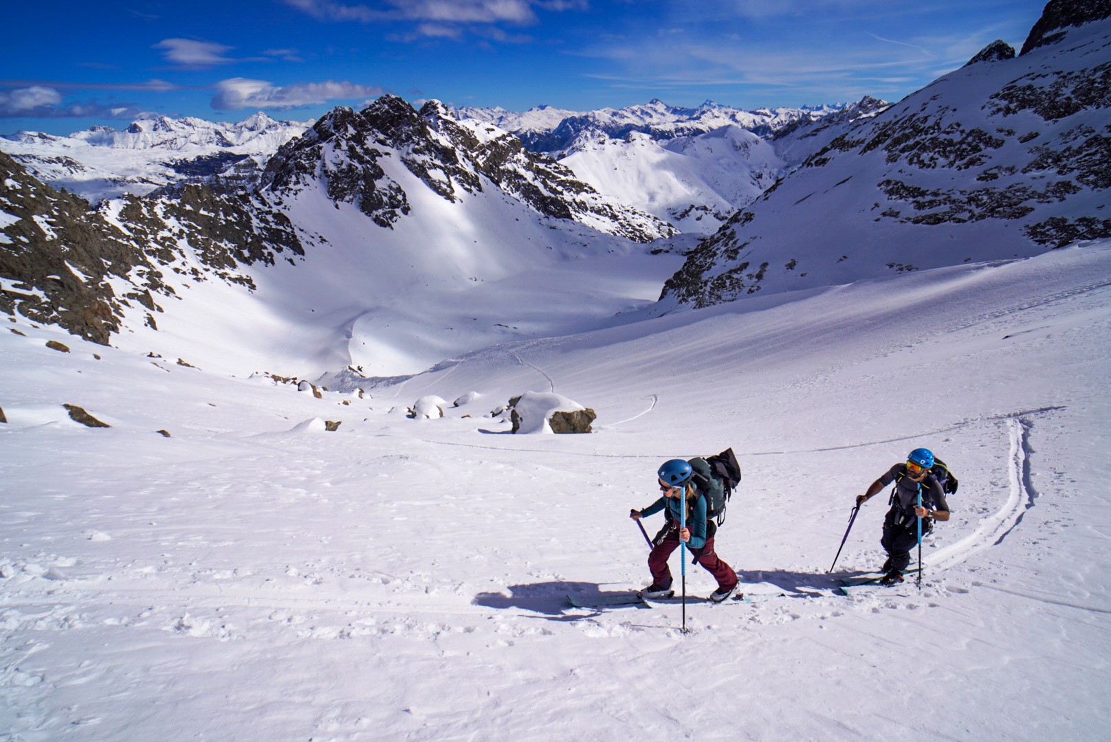 Deux skieurs de randonnée remontant un glacier, avec un vallon enneigé en contrebas, Tour des Agneaux (Écrins)