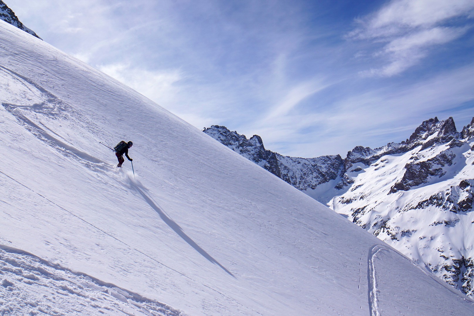 Skieur en descente sur une longue pente de neige, ombre portée sur le manteau neigeux, Tour des Agneaux (Écrins)