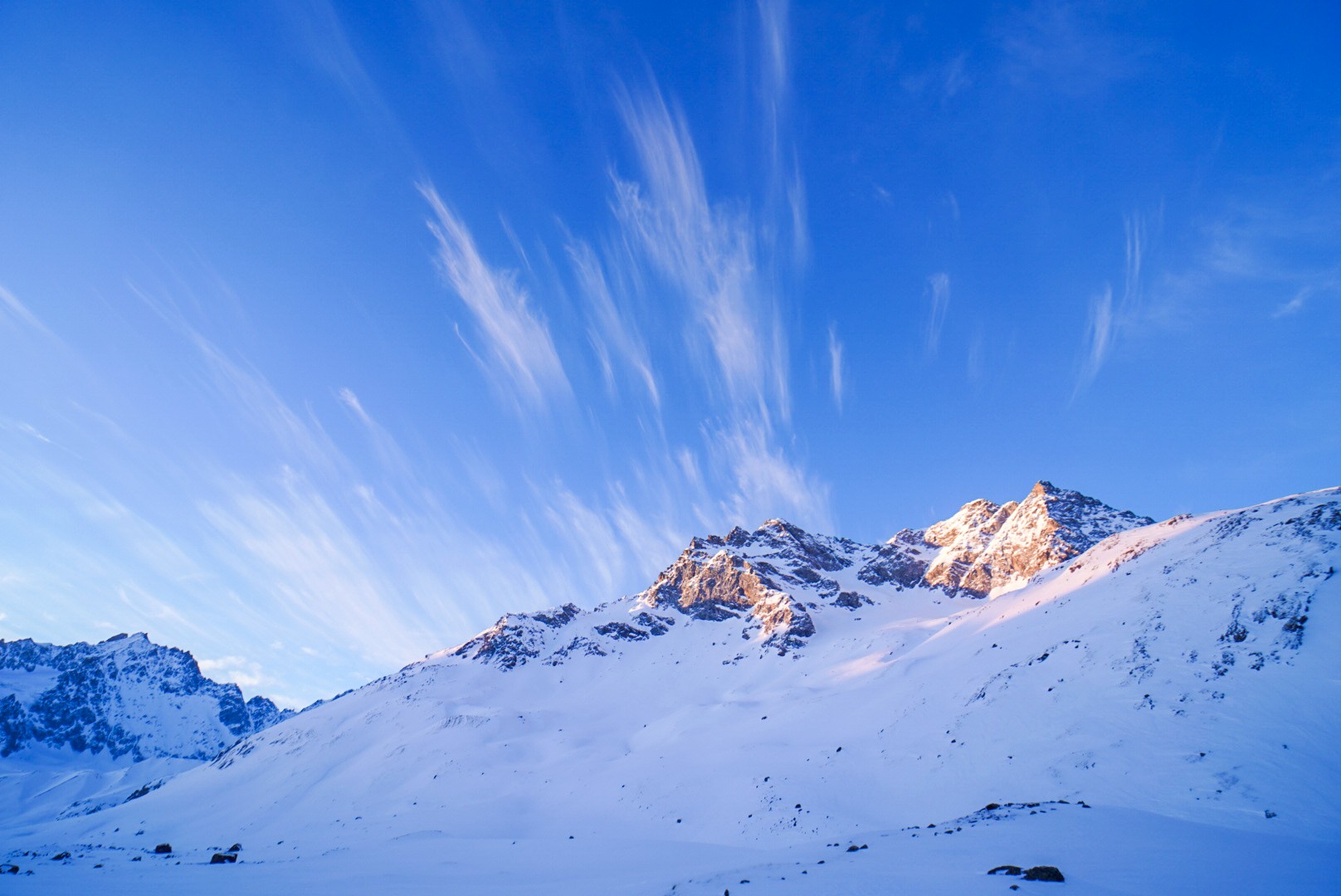 Crêtes enneigées éclairées par la lumière du matin, sous un ciel strié de nuages, Tour des Agneaux (Écrins)