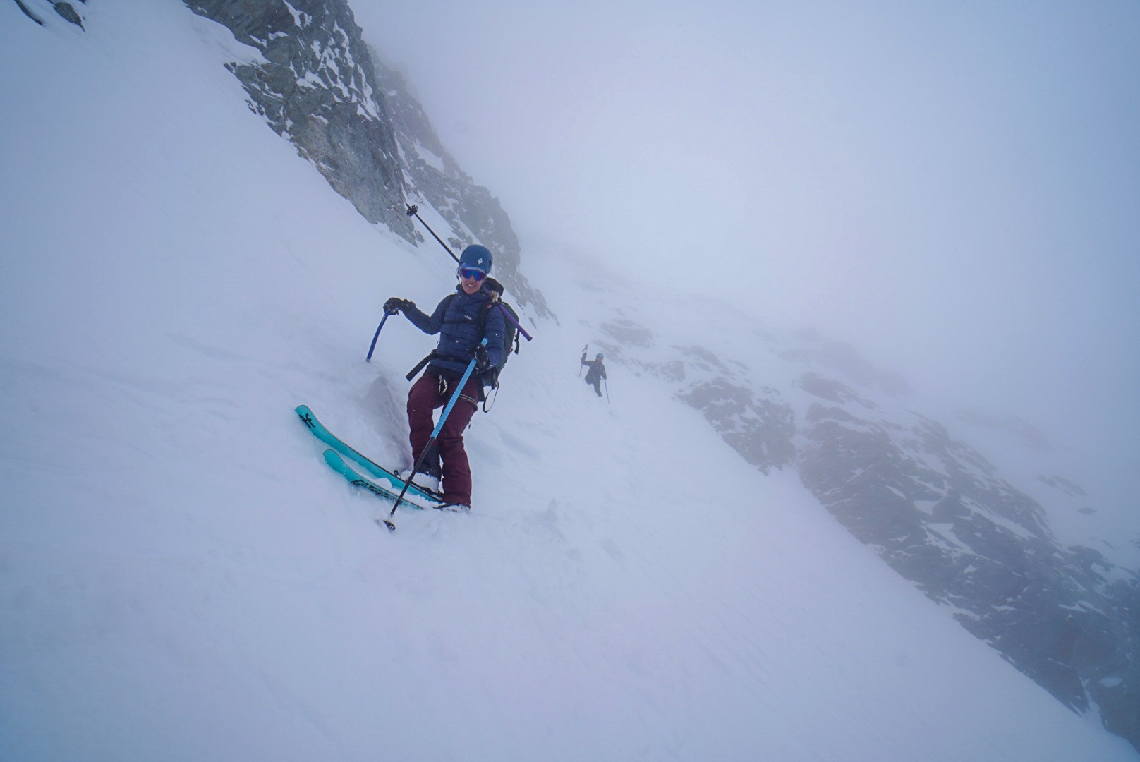 Skieur dans un couloir raide enneigé, un second skieur plus bas, dans la brume, Tour des Agneaux (Écrins)