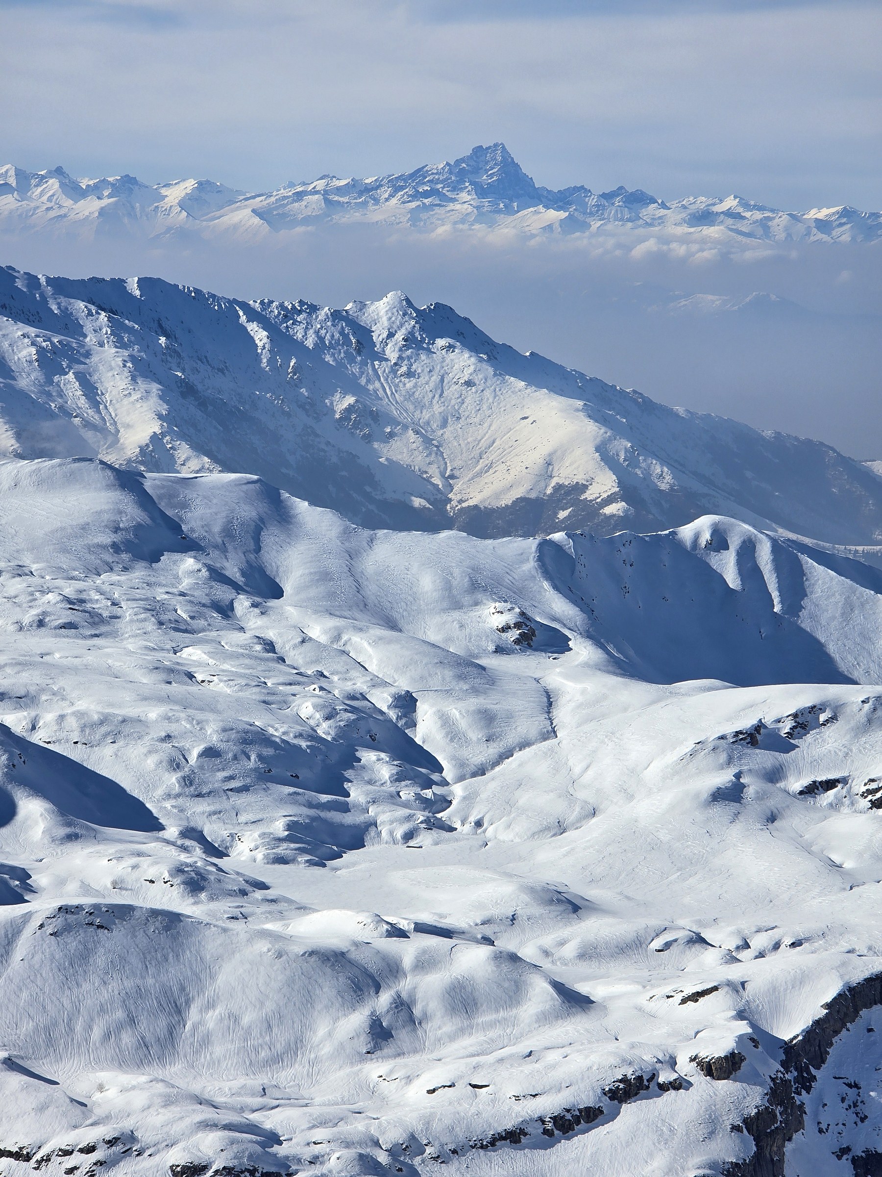 Panorama sur les reliefs enneigés pendant la traversée à ski des Alpes ligures, au jour 3 de l’itinérance.