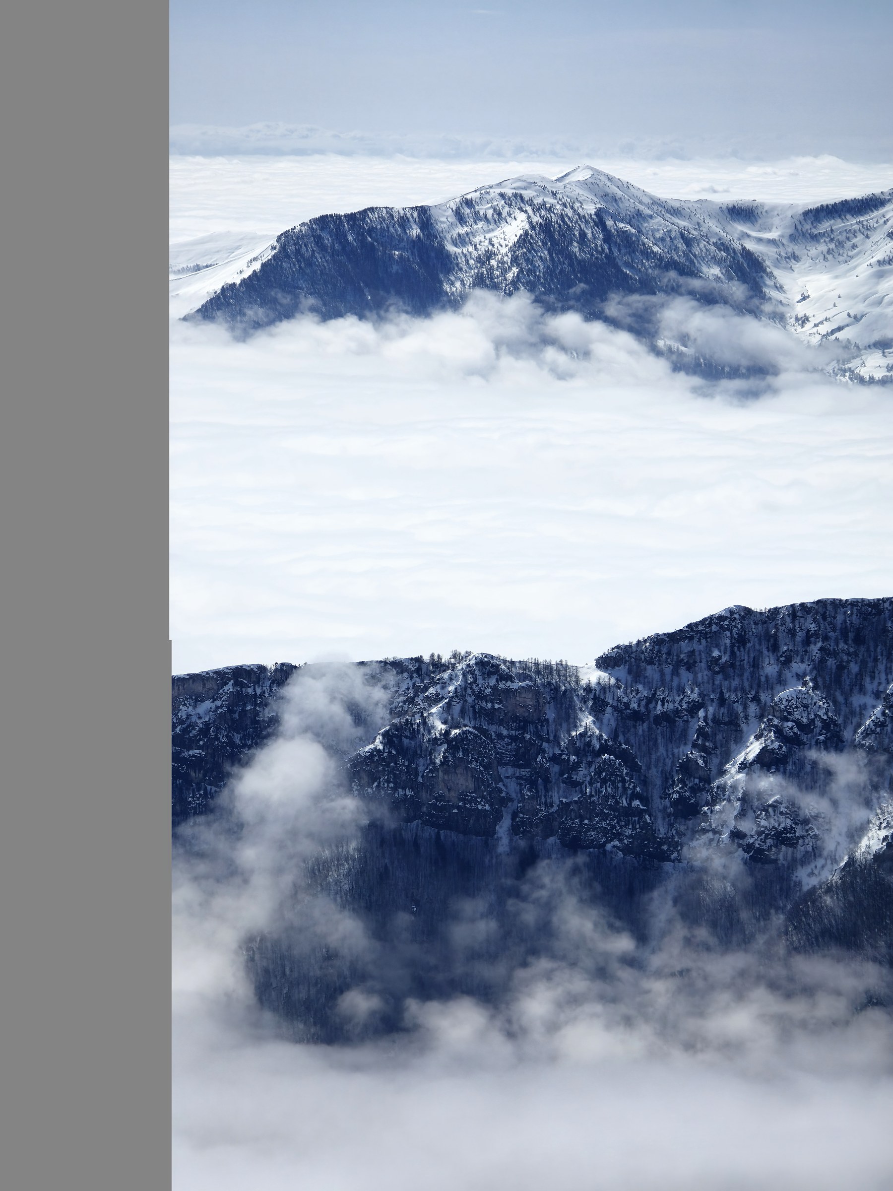Vallée au-dessus d’une mer de nuages pendant la traversée à ski des Alpes ligures, au jour 4 de l’itinérance.