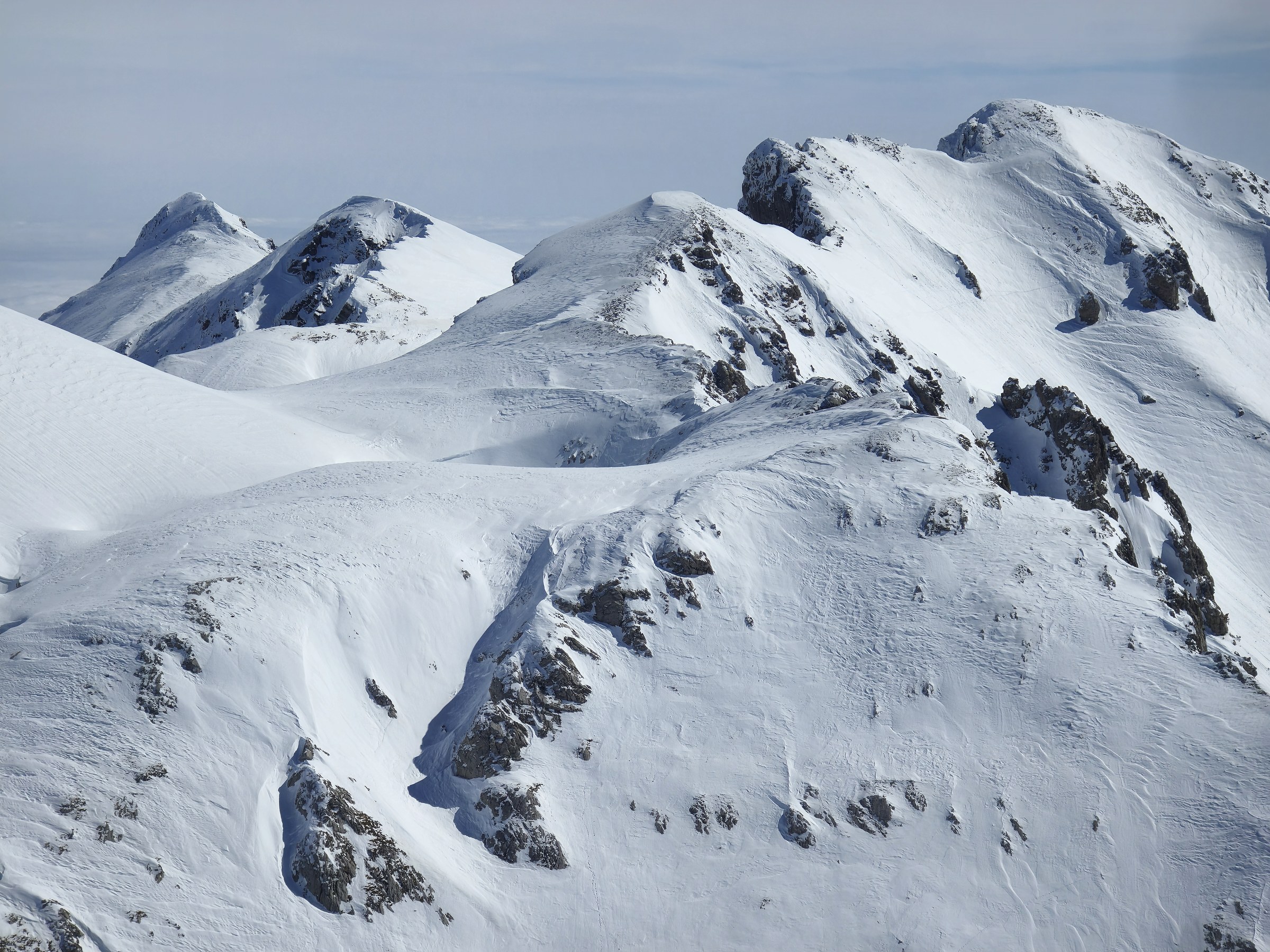 Enchaînement de sommets enneigés pendant la traversée à ski des Alpes ligures, au jour 4 de l’itinérance.