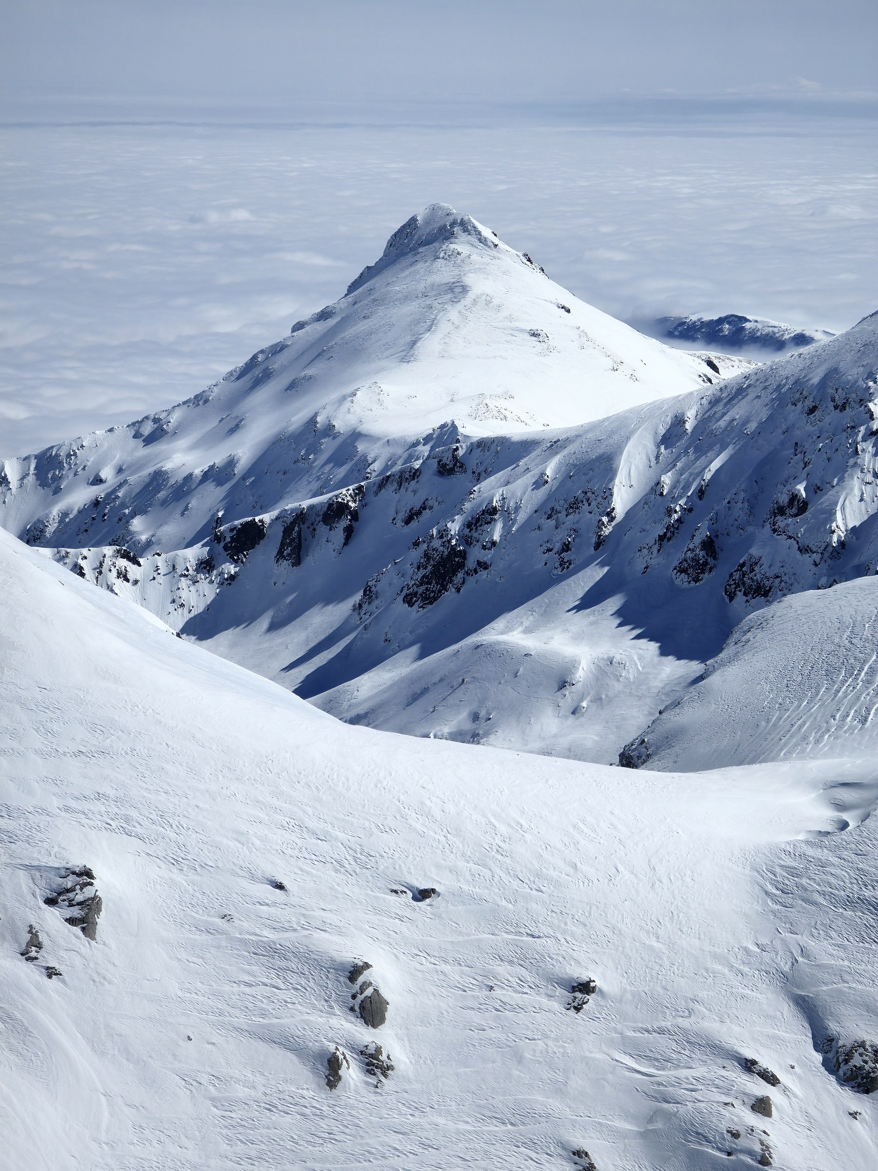 Descente dans une grande combe pendant la traversée à ski des Alpes ligures, au jour 4 de l’itinérance.