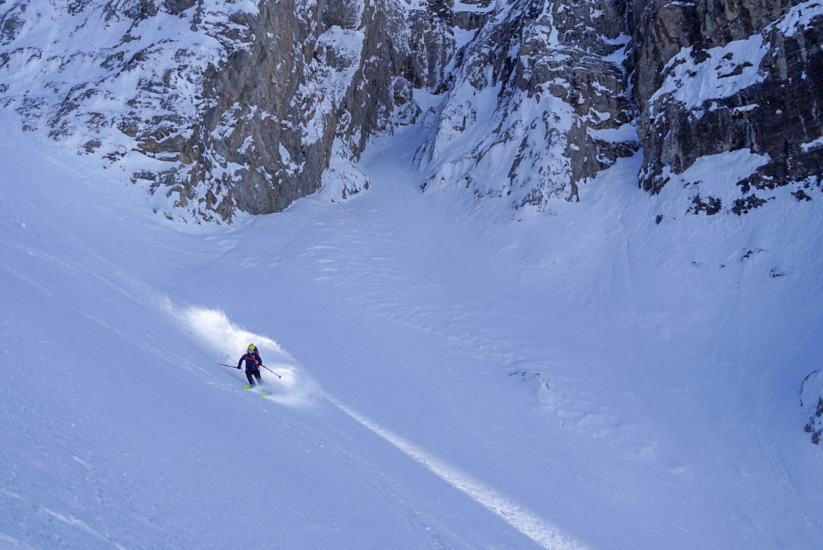 Skieur dans un couloir enneigé pendant la traversée à ski des Alpes ligures, au jour 2 de l’itinérance.