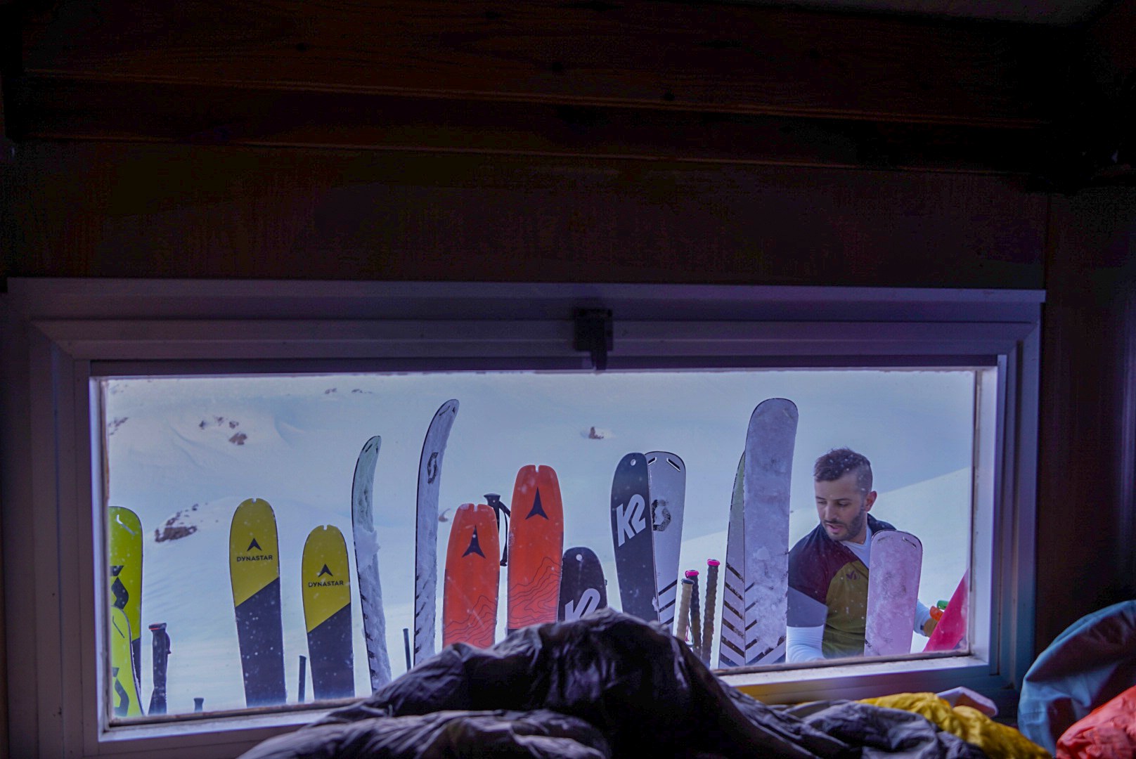 Soir tombant derrière la vitre du refuge pendant la traversée à ski des Alpes ligures, au jour 2 de l’itinérance.