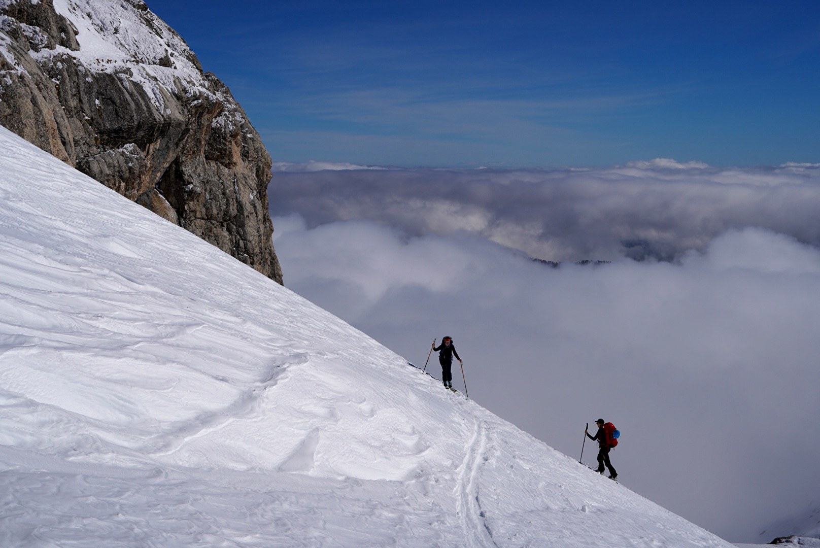 Groupe montant sur une arête aérienne pendant la traversée à ski des Alpes ligures, au jour 3 de l’itinérance.