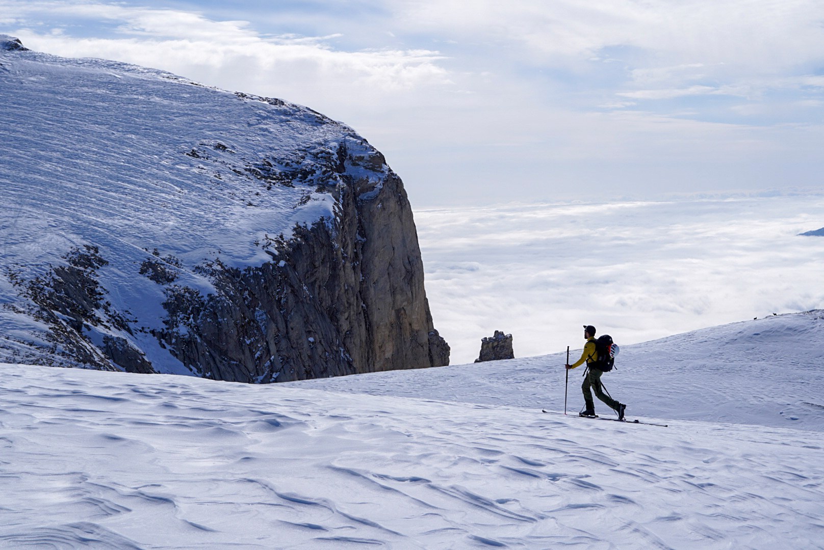 Montée au bord d’une falaise au-dessus des nuages pendant la traversée à ski des Alpes ligures, au jour 4 de l’itinérance.