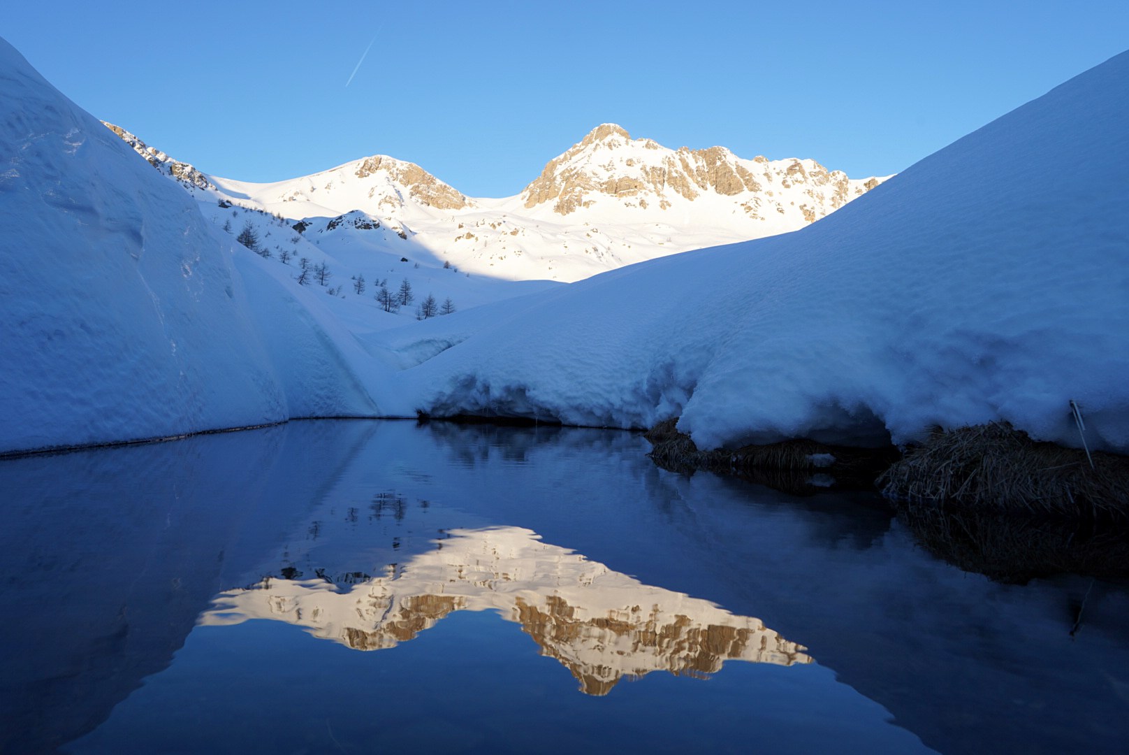 Reflet des sommets dans une mare de fonte pendant la traversée à ski des Alpes ligures, au jour 5 de l’itinérance.