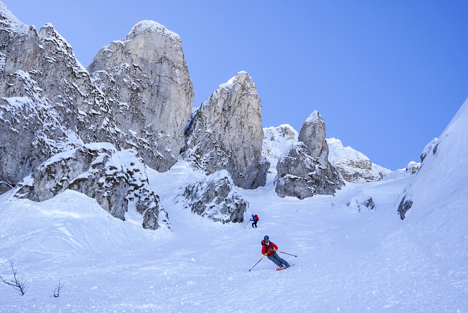 Descente entre les tours rocheuses pendant la traversée à ski des Alpes ligures, au jour 5 de l’itinérance.