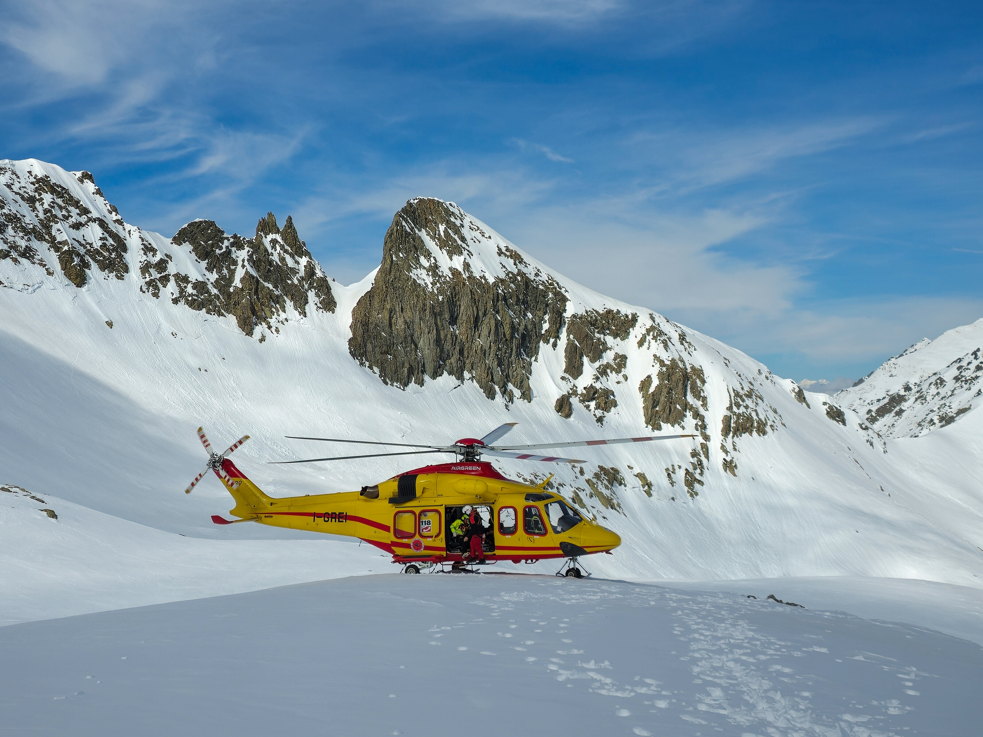 hélicoptère posé sur la neige près d'un groupe de skieurs de randonnée