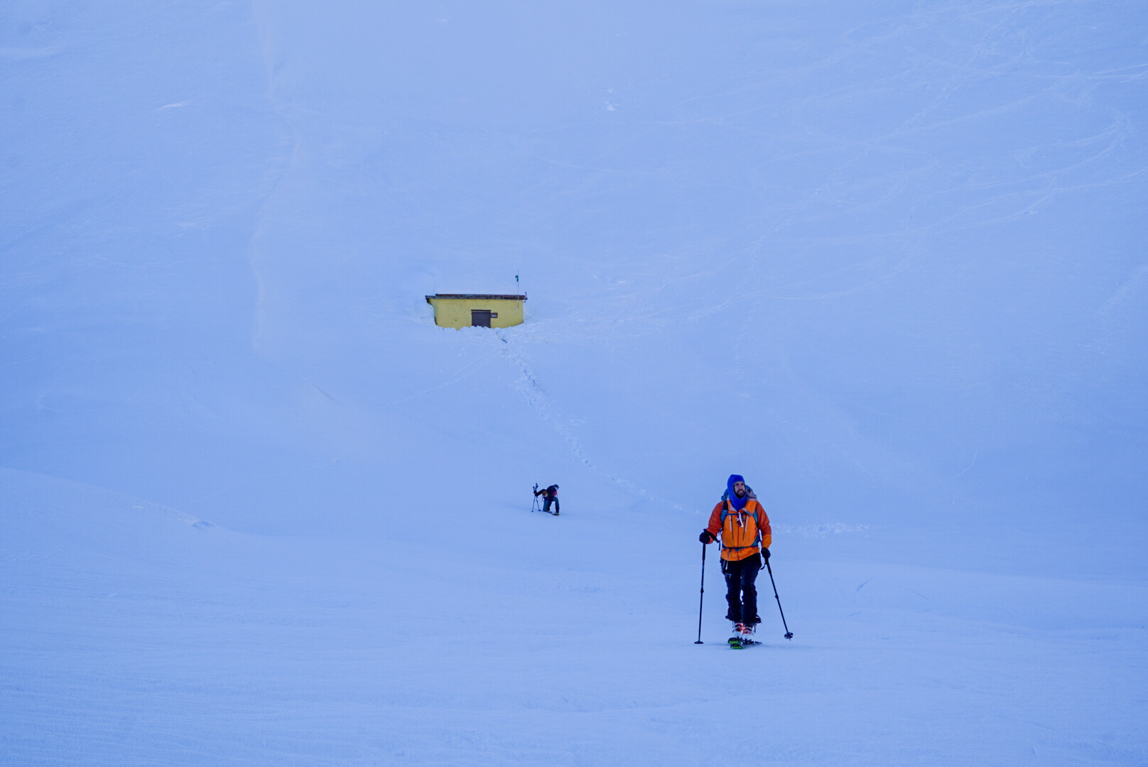 groupe de skieurs de randonnée progressant vers un col rocheux
