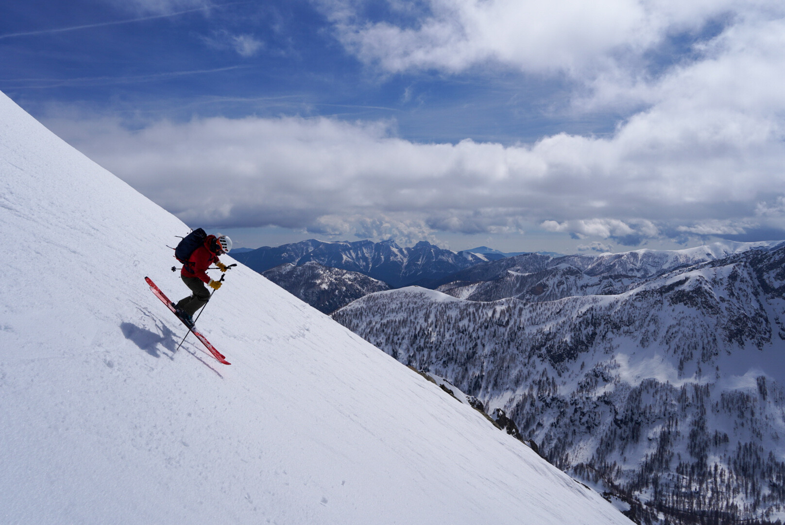 skieur de randonnée seul au sommet d'une arête enneigée au coucher du soleil