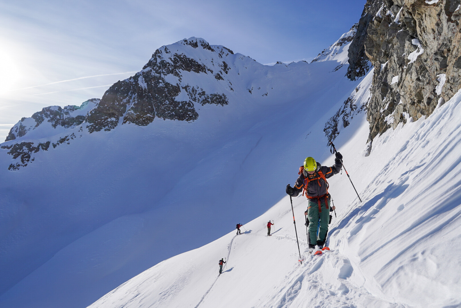 groupe de skieurs de randonnée progressant sous un ciel nuageux