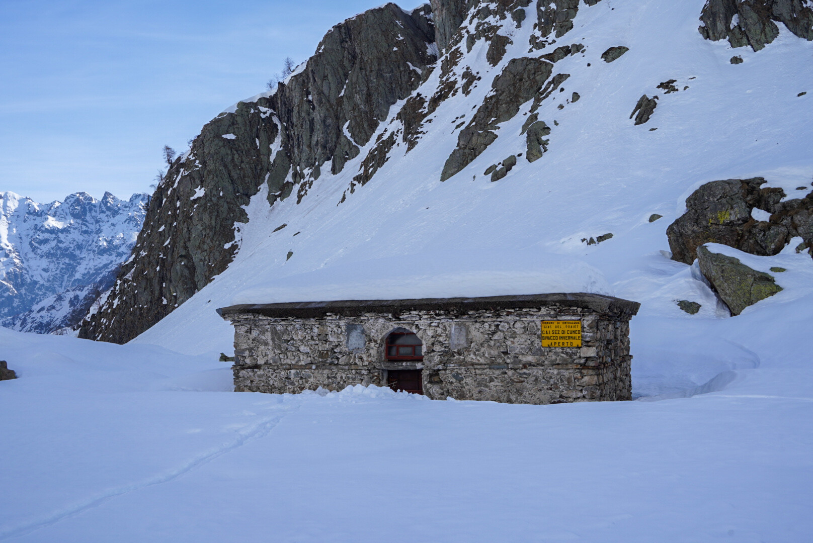 traces de conversion sur un glacier, deux skieurs au loin