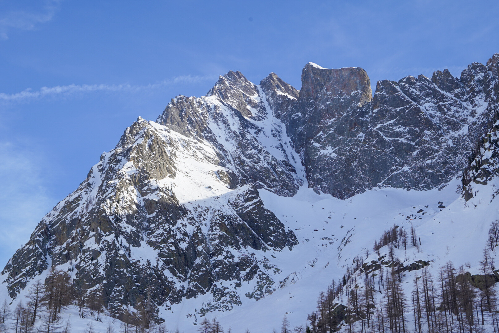 deux skieurs de randonnée montant vers un col rocheux