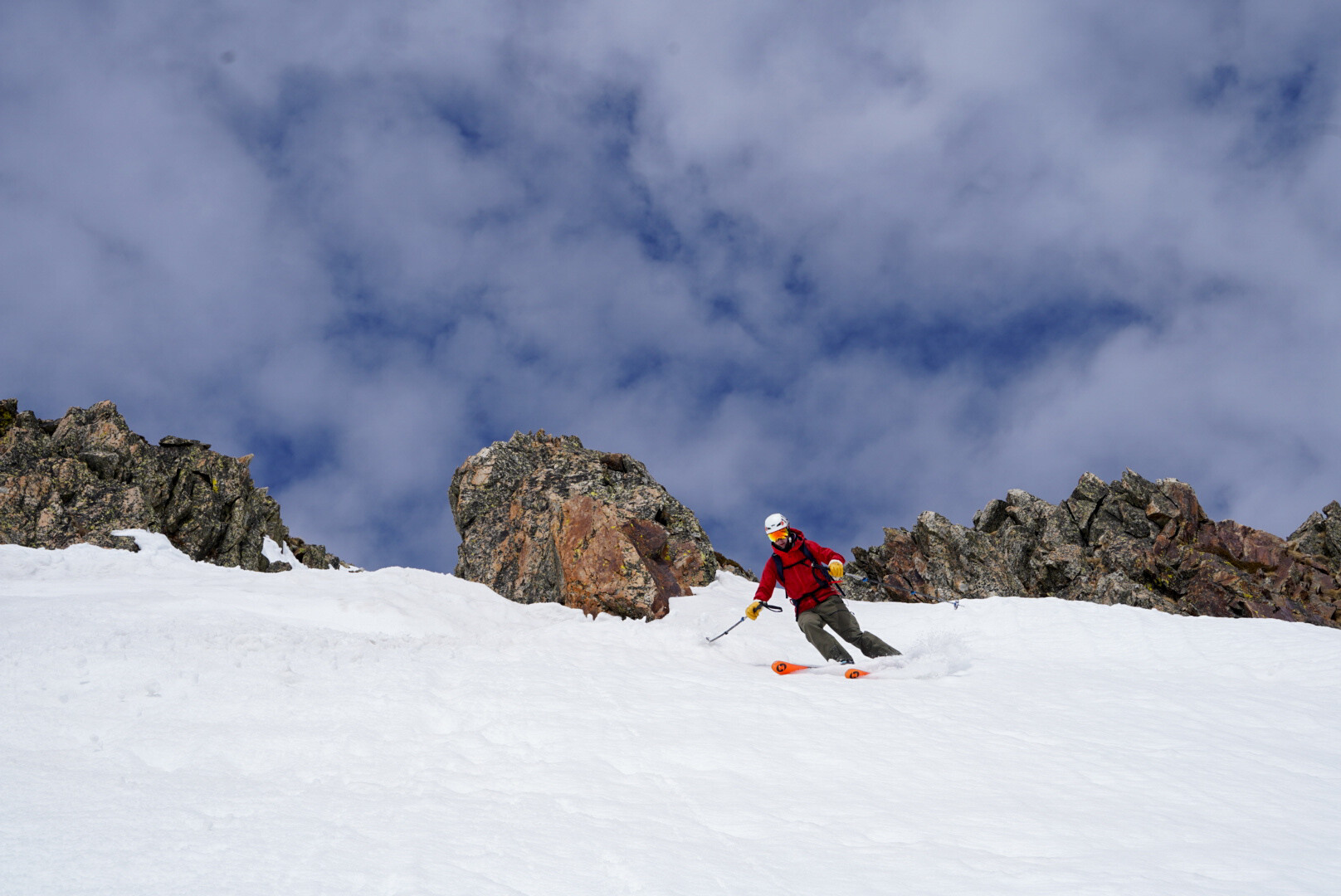 skieur de randonnée descendant un couloir étroit entre les rochers