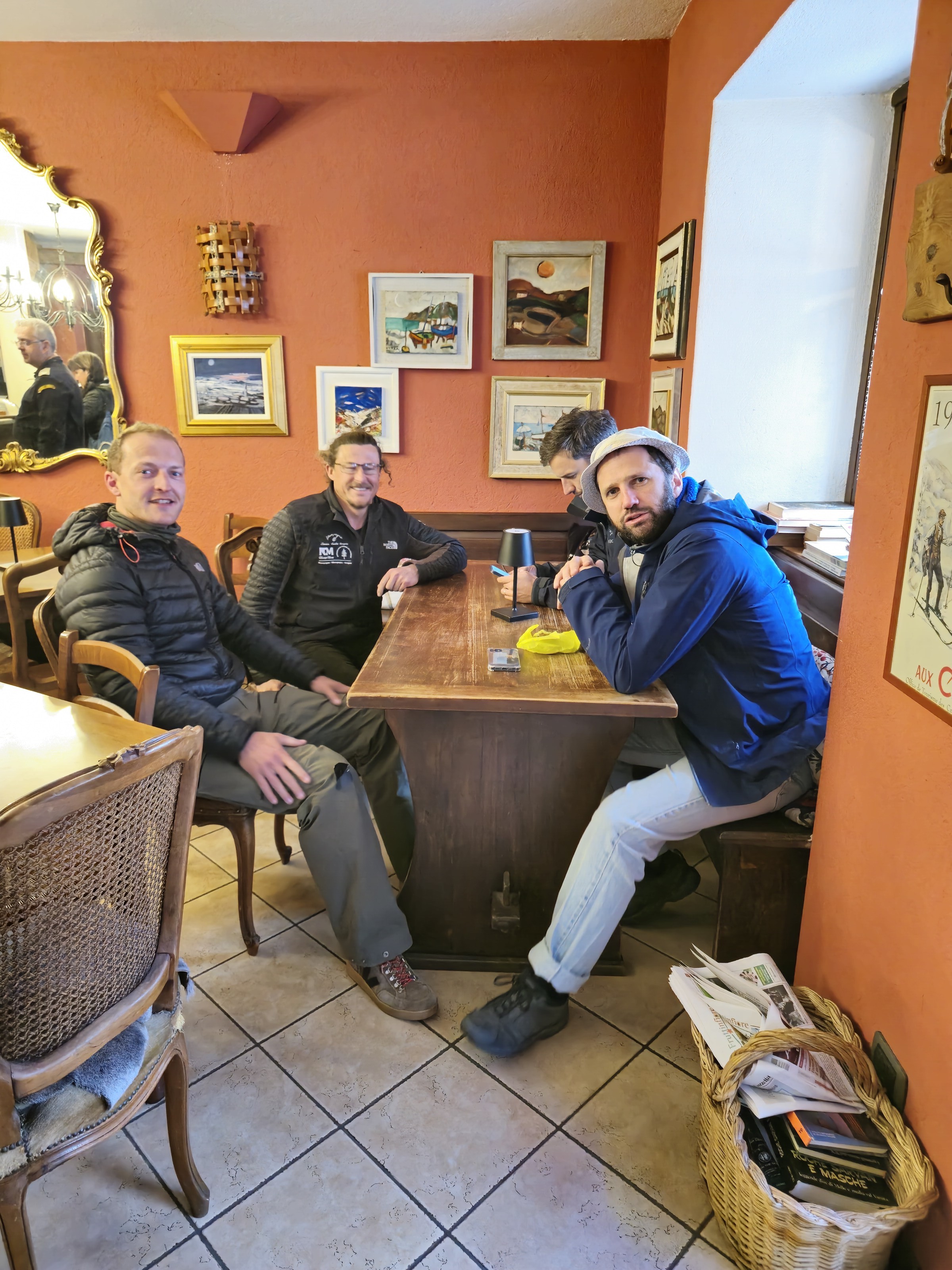 groupe attablé dans une salle de refuge décorée, petit-déjeuner avant le départ