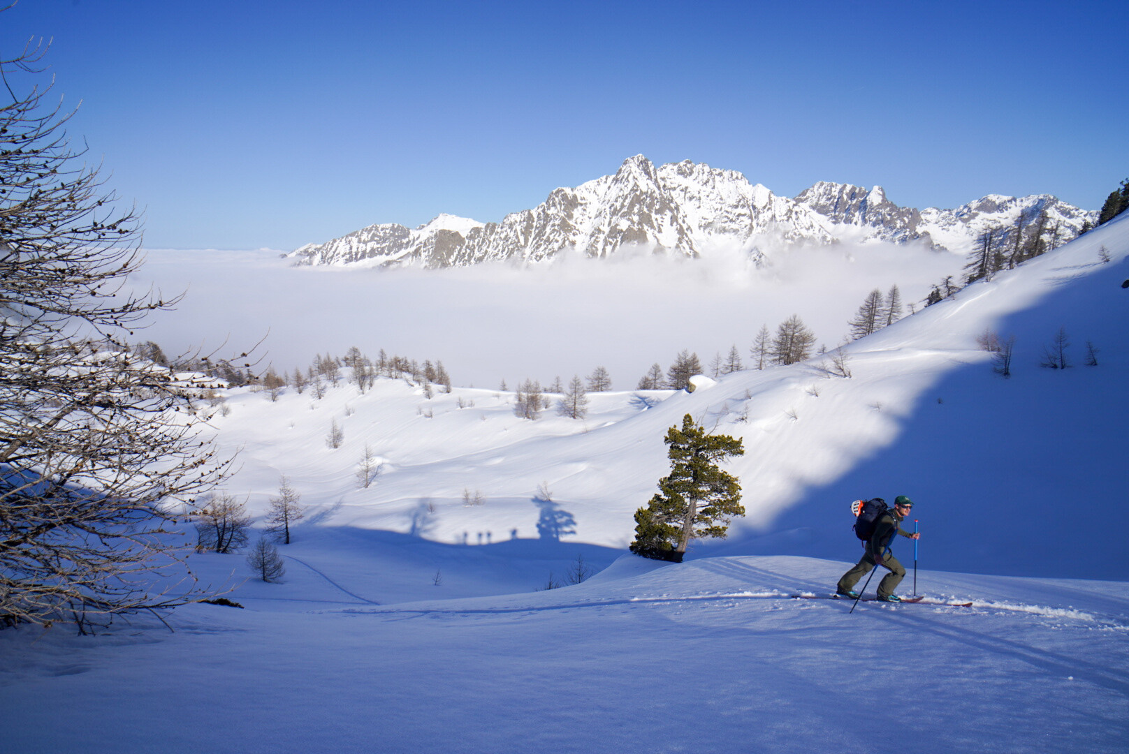 skieur de randonnée seul sur une large pente enneigée