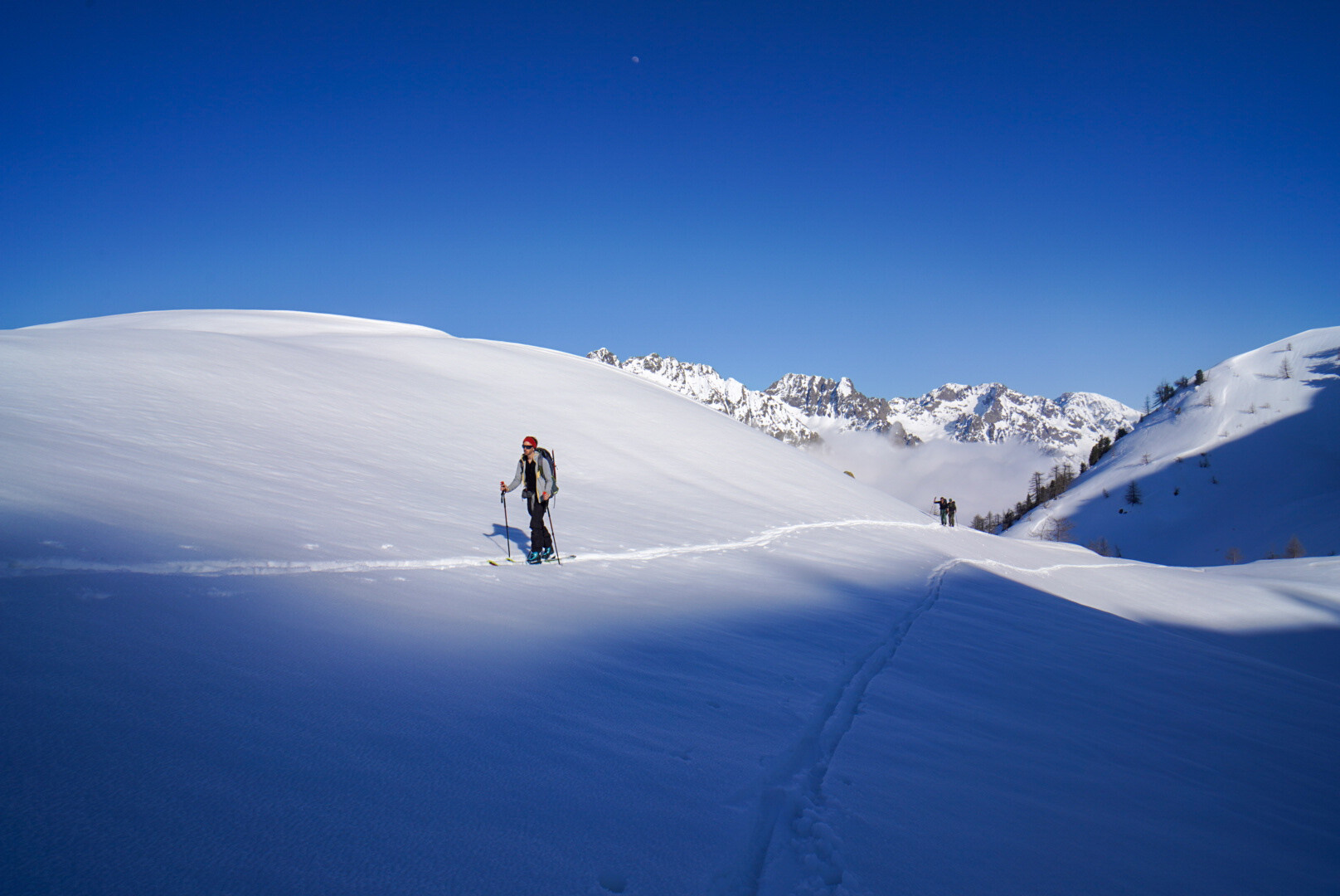 groupe de skieurs de randonnée progressant sur une crête dégagée