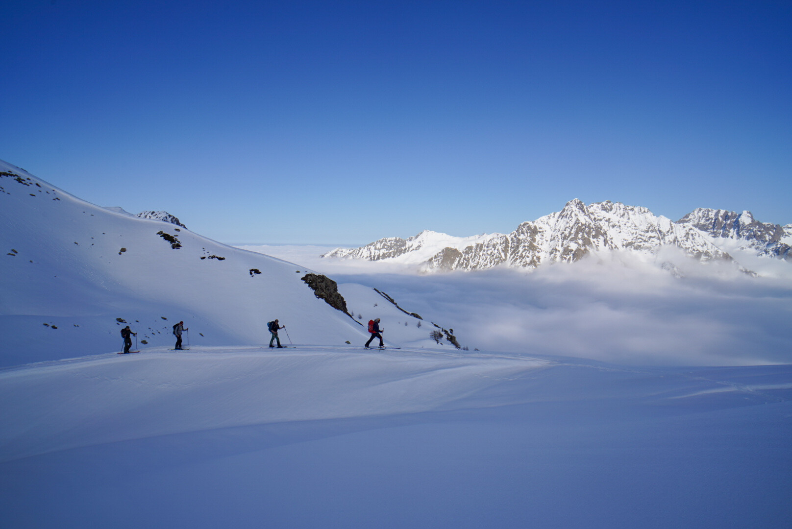 deux skieurs de randonnée en ascension vers un sommet enneigé