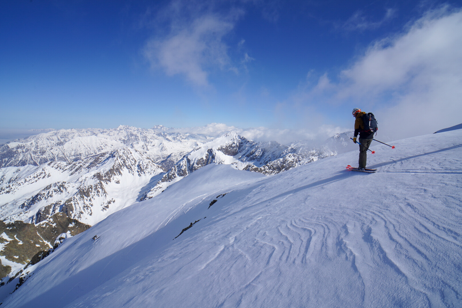 groupe de skieurs de randonnée en file sur un vaste plateau enneigé