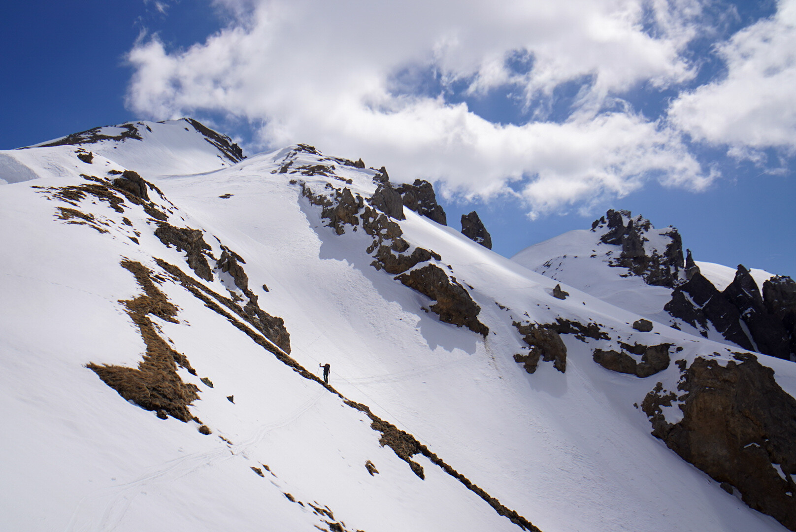 glacier parcouru par un skieur de randonnée isolé, traces de montée