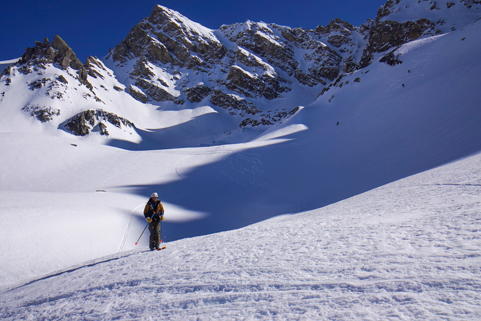 groupe de skieurs de randonnée franchissant un col rocheux