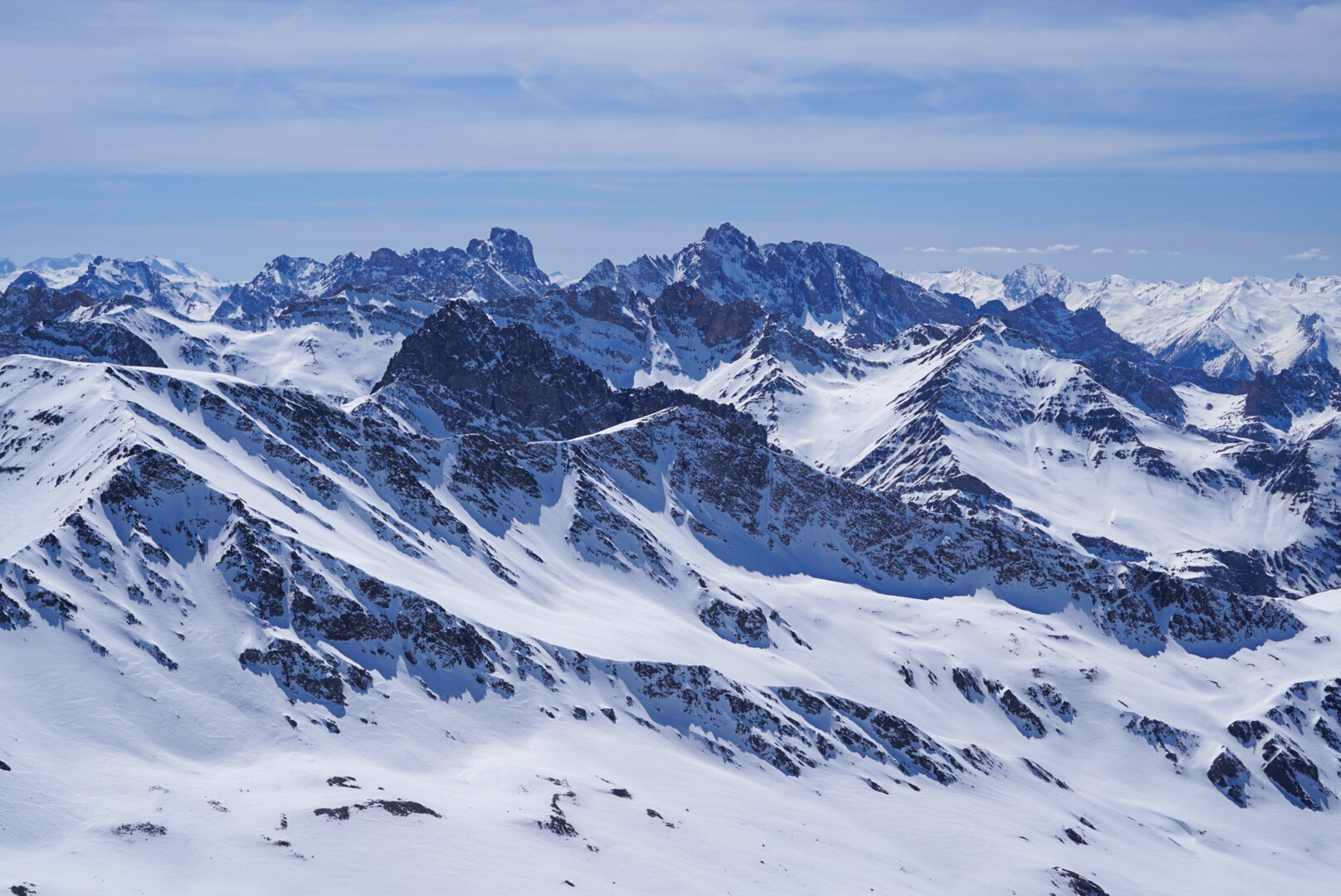 deux skieurs de randonnée devant un refuge de montagne en pierre, ravitaillement