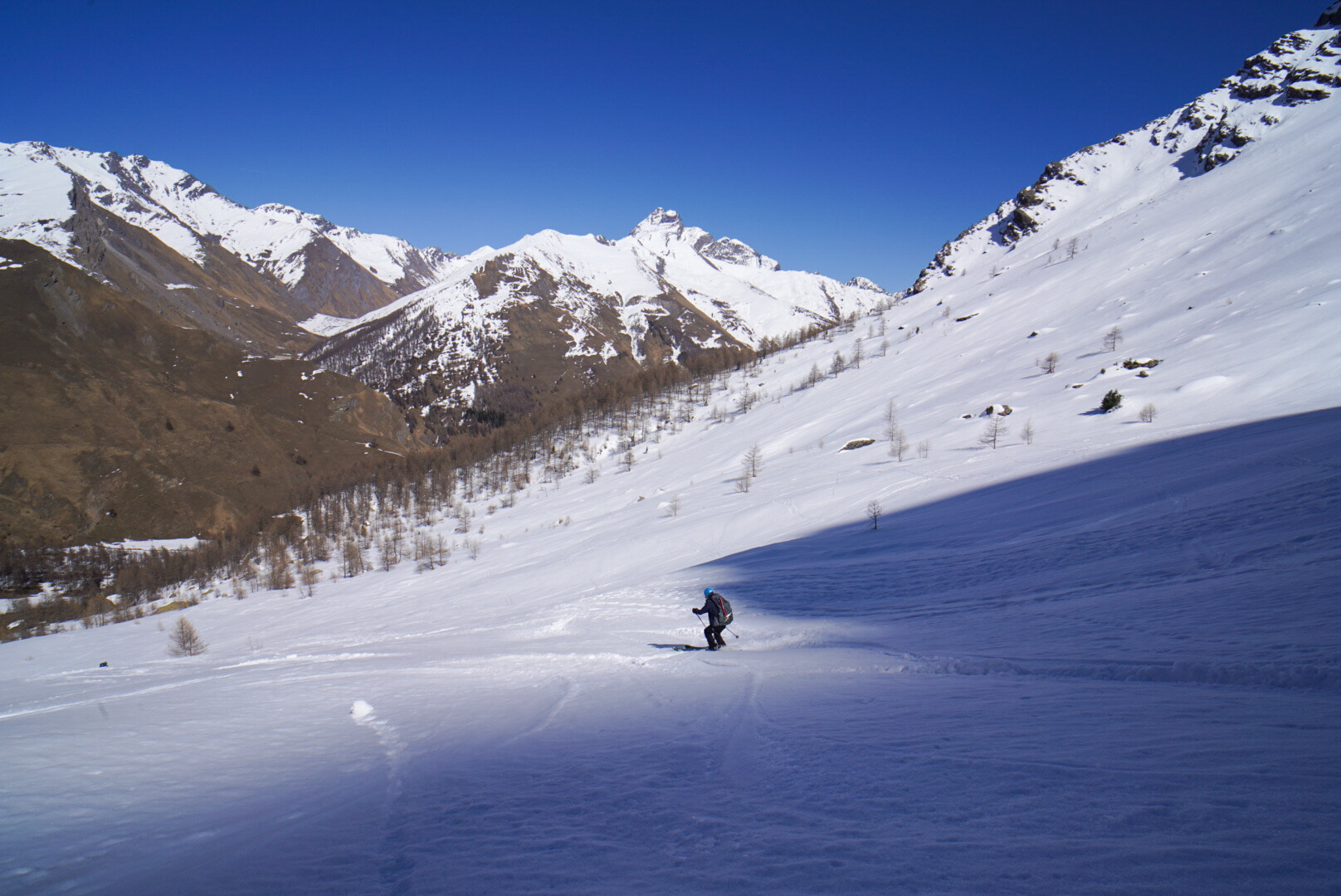 skieur de randonnée descendant vers le village de Pontechianale