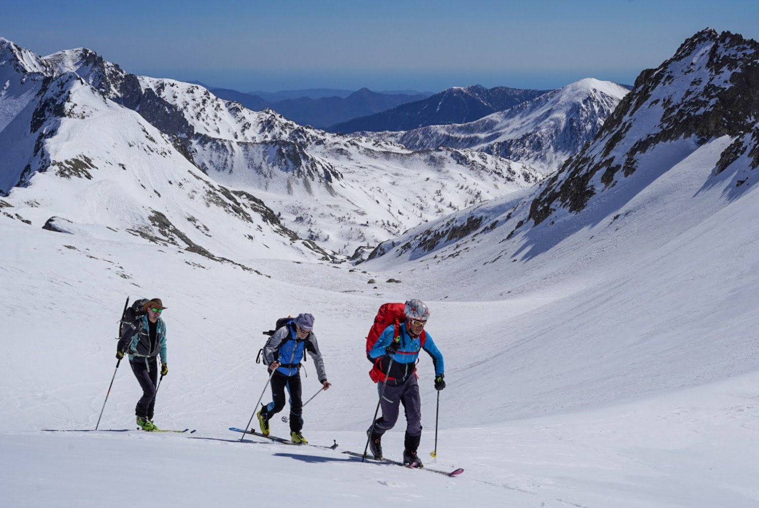 Trois skieurs de randonnée en ligne, ascension dans le massif du Mercantour