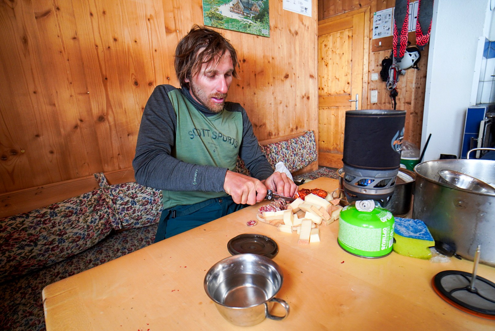 Compagnon cuisinant dans la salle en bois du refuge, étape Hochjoch Hospiz – Vernagthütte, dans les Alpes de l’Ötztal en Autriche.
