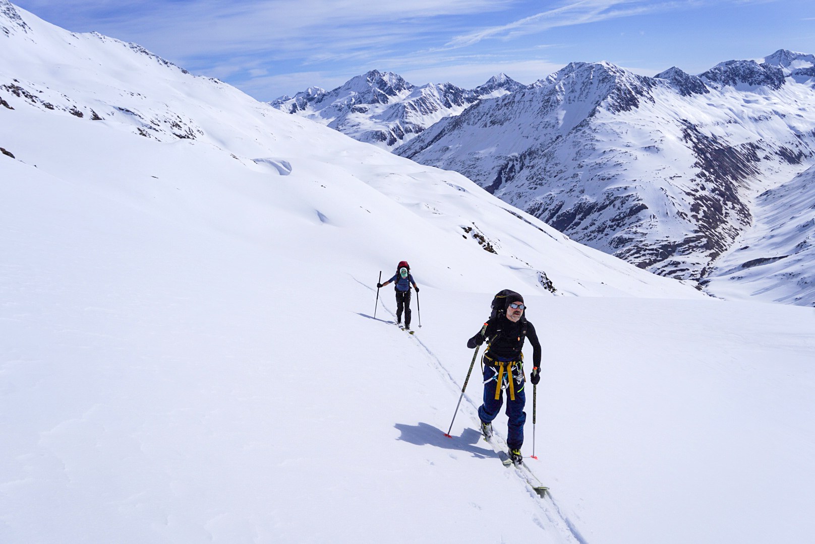 Skieurs montant sur une pente panoramique, étape Martin-Busch-Hütte – Hochjoch Hospiz, dans les Alpes de l’Ötztal en Autriche.