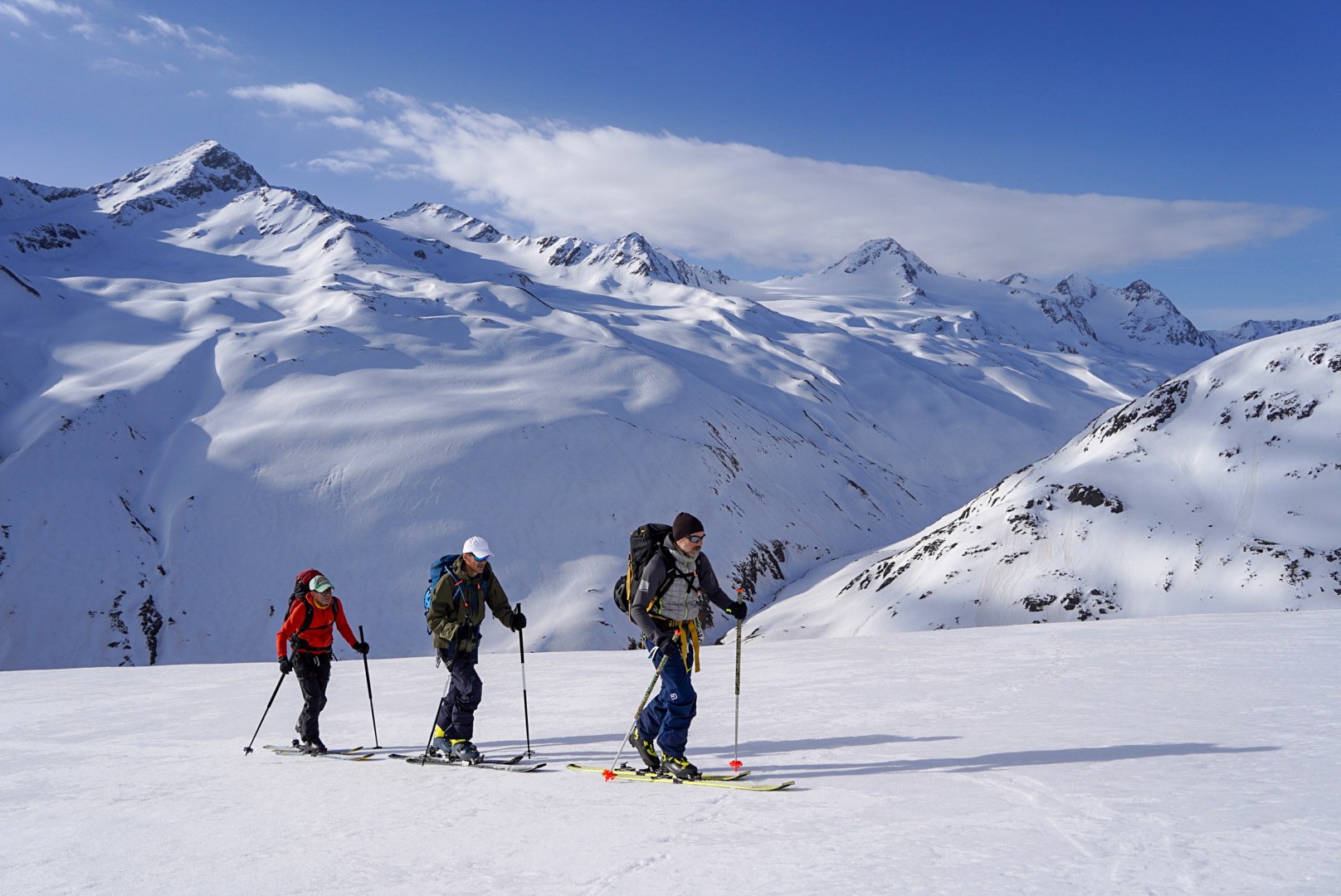 Skieurs gravissant une pente ensoleillée, étape Hochjoch Hospiz – Vernagthütte, dans les Alpes de l’Ötztal en Autriche.