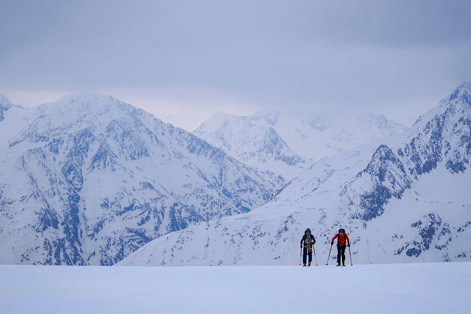 Deux skieurs traversant un plateau face aux sommets, étape Vernagthütte – Sölden, dans les Alpes de l’Ötztal en Autriche.