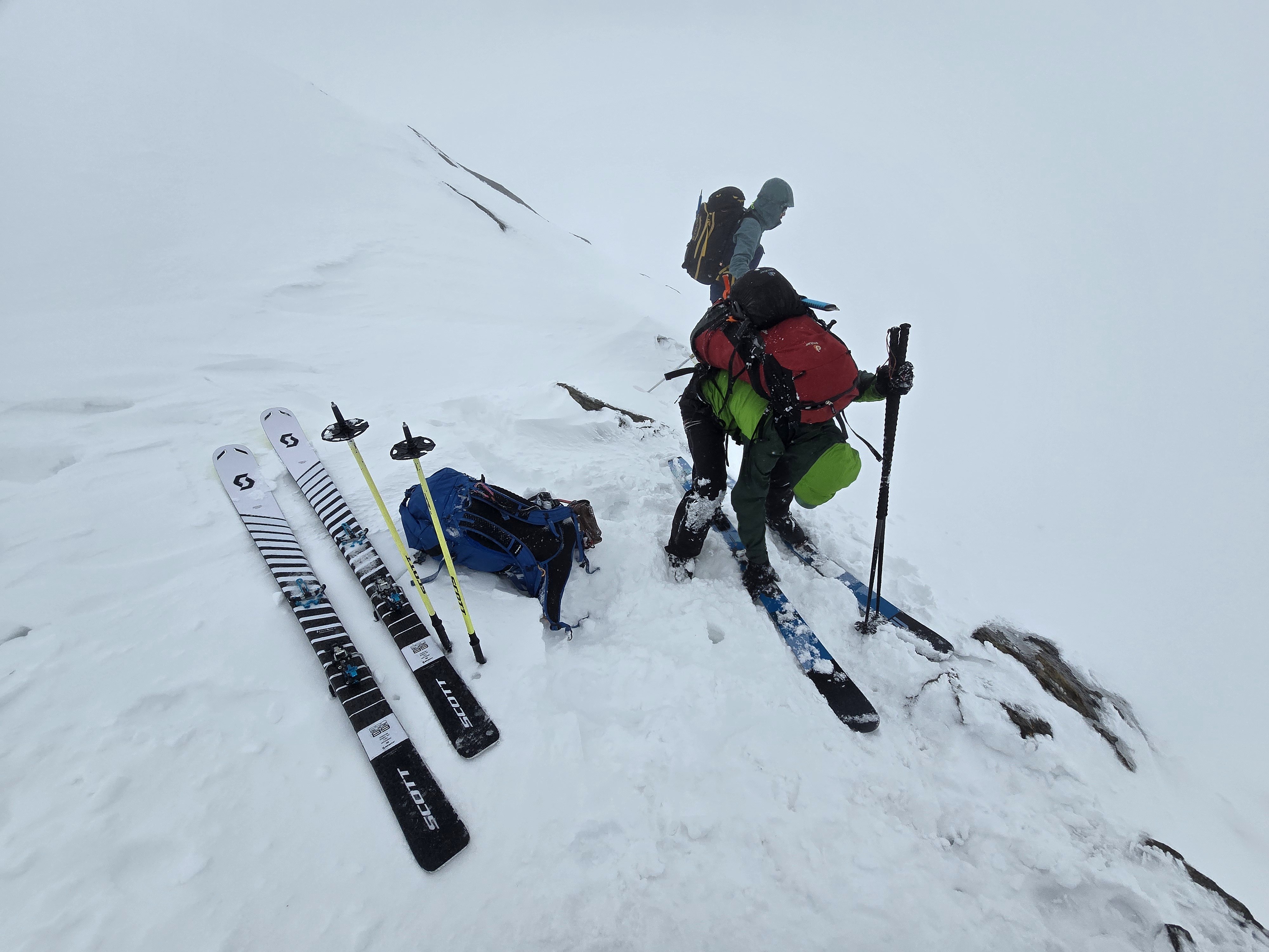 Skieurs regroupés avec les skis posés sur la neige dans le brouillard, étape Fidelitas Hütte – Martin-Busch-Hütte, dans les Alpes de l’Ötztal en Autriche.