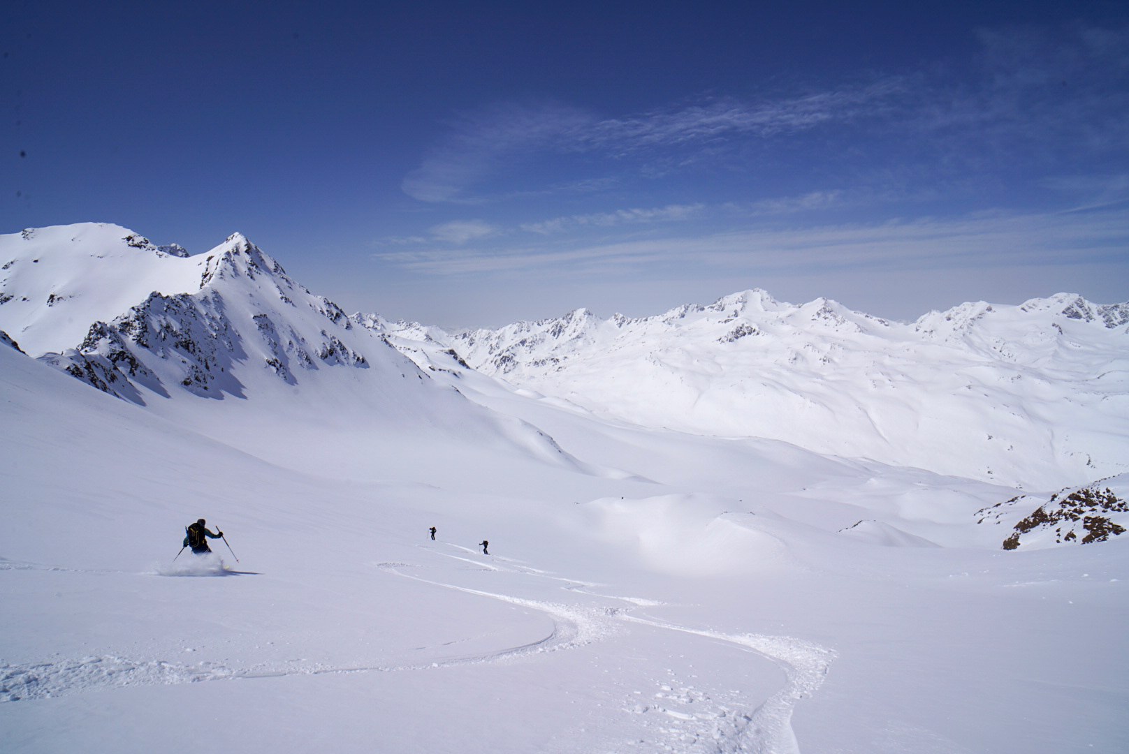 Skieur traçant une vaste combe enneigée, étape Martin-Busch-Hütte – Hochjoch Hospiz, dans les Alpes de l’Ötztal en Autriche.