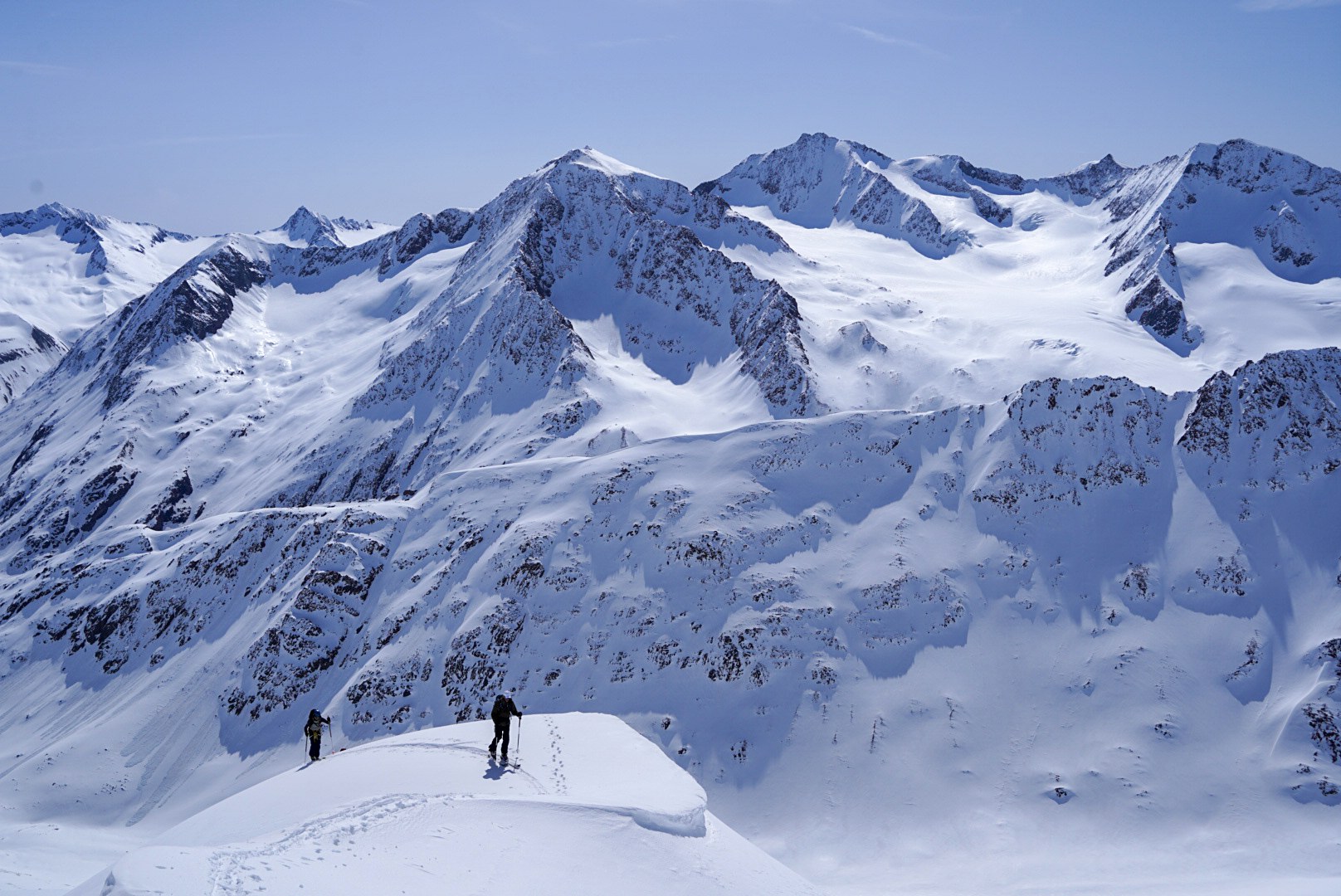 Deux skieurs avançant sur une arête au-dessus des glaciers, étape Martin-Busch-Hütte – Hochjoch Hospiz, dans les Alpes de l’Ötztal en Autriche.