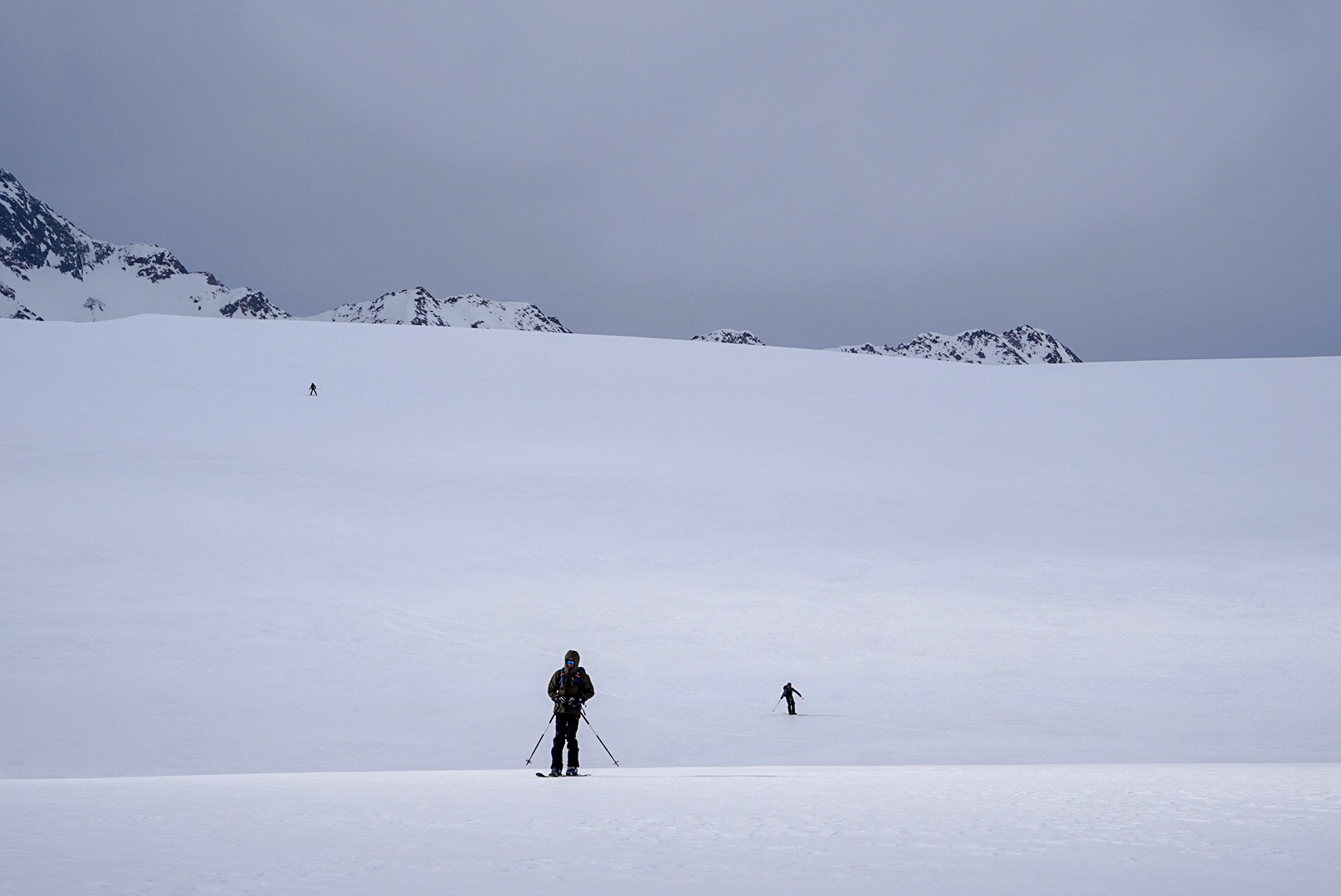 Deux silhouettes progressant dans un vaste paysage enneigé, étape Vernagthütte – Sölden, dans les Alpes de l’Ötztal en Autriche.