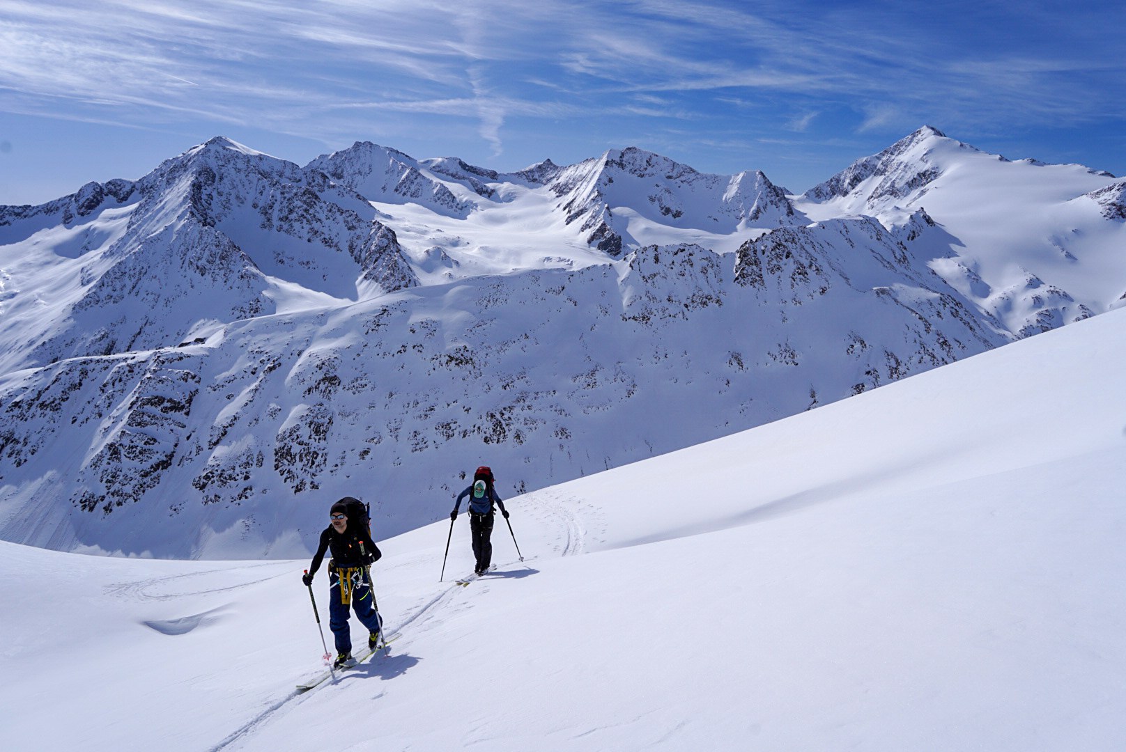 Deux skieurs progressant devant les glaciers et sommets tyroliens, étape Martin-Busch-Hütte – Hochjoch Hospiz, dans les Alpes de l’Ötztal en Autriche.