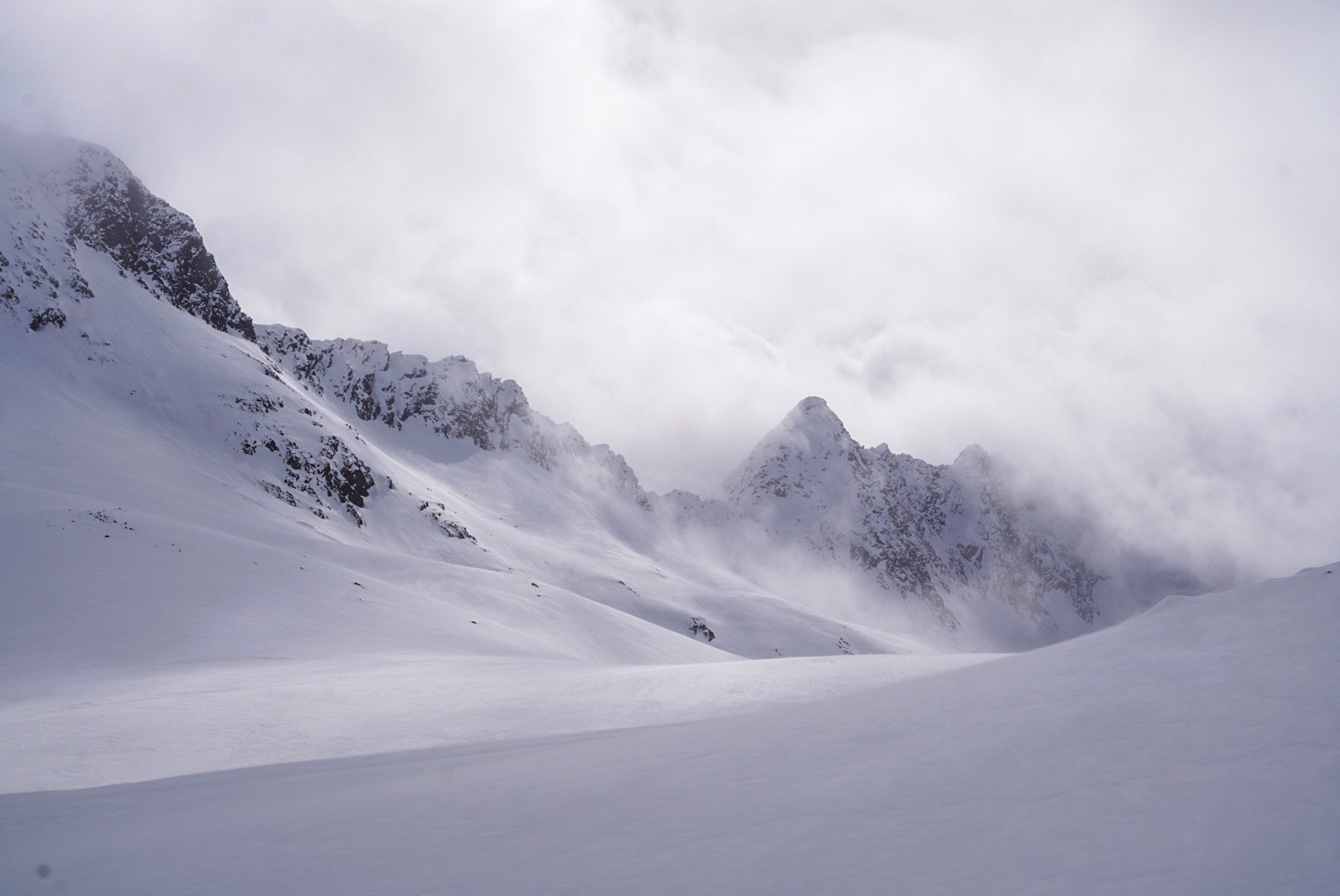 Grand vallon enneigé encadré de sommets dans les nuages, étape Fidelitas Hütte – Martin-Busch-Hütte, dans les Alpes de l’Ötztal en Autriche.