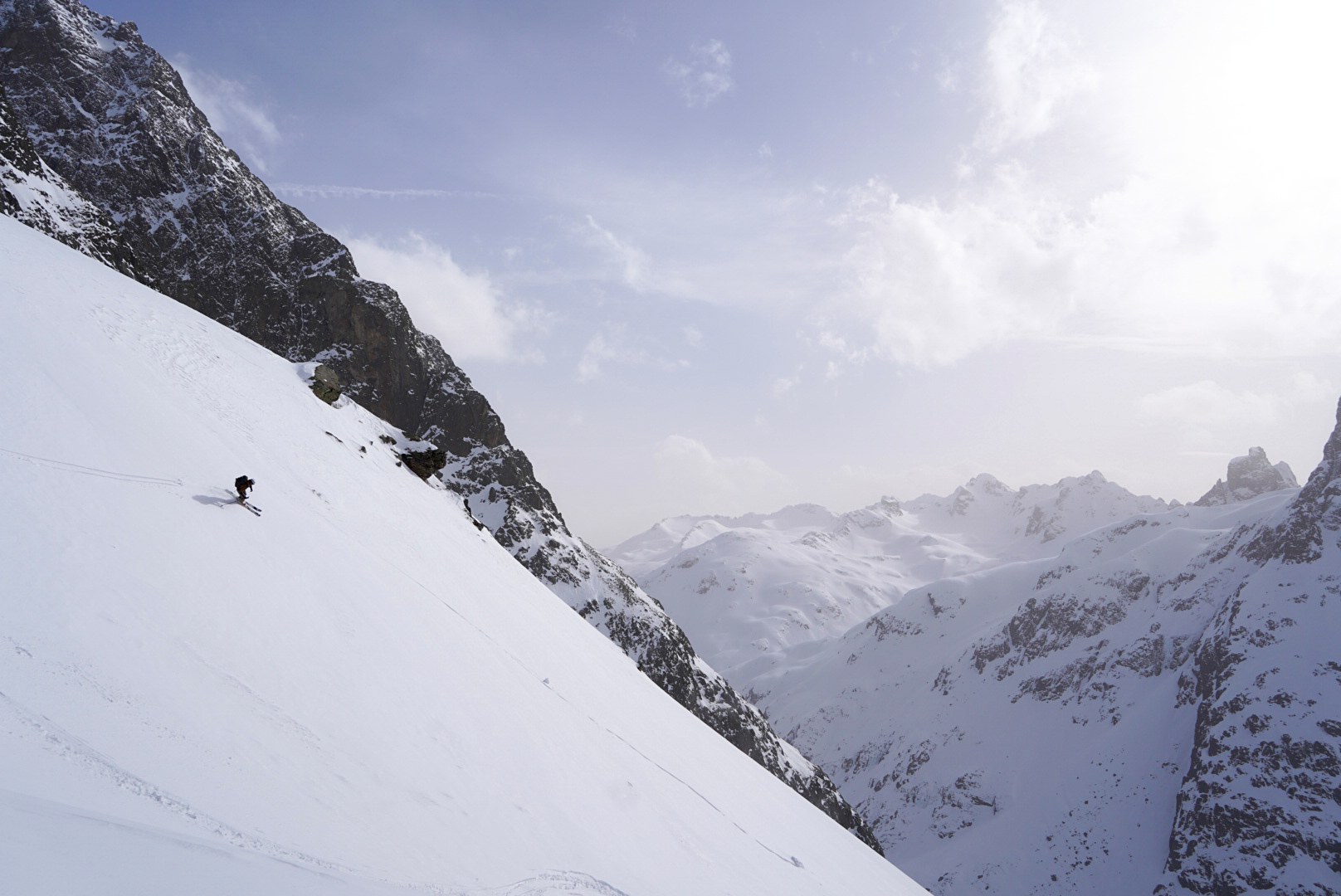 Descente sous une grande paroi pendant le tour à ski du Verwall au Tyrol, au jour 1 de l’itinérance.