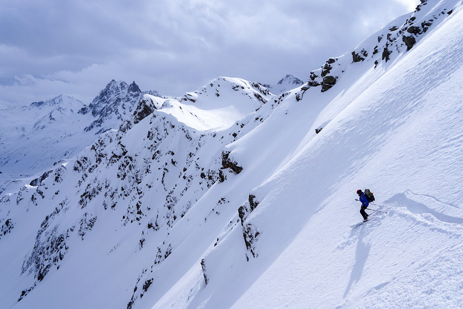 Descente d’un skieur sur une pente raide pendant le tour à ski du Verwall au Tyrol, au jour 3 de l’itinérance.