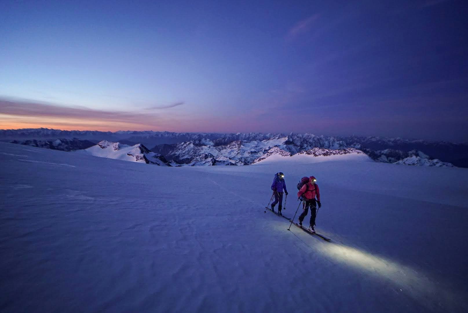 Les premières lueurs colorent les montagnes au-dessus du glacier.