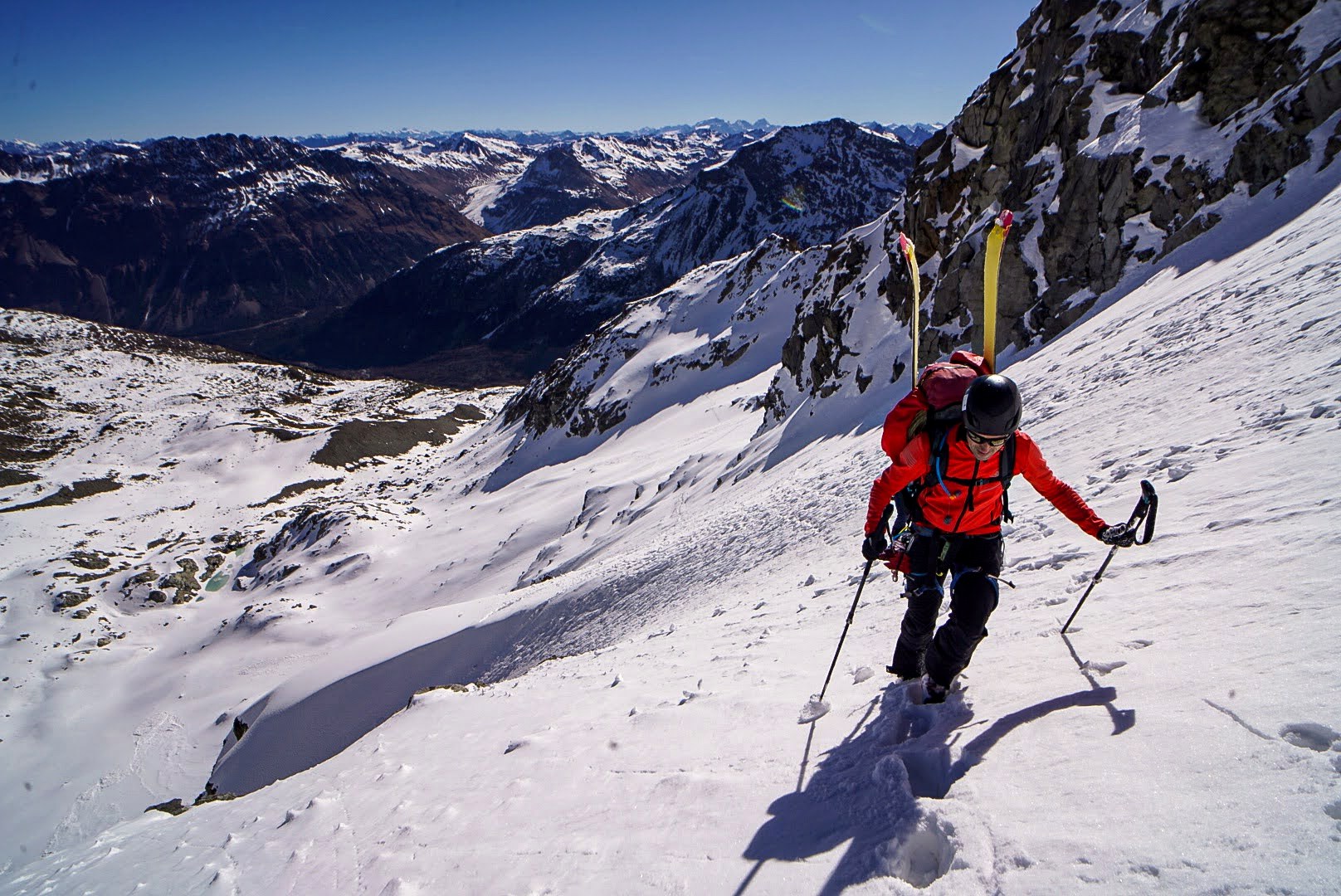 Deux skieurs descendent une grande pente glaciaire.