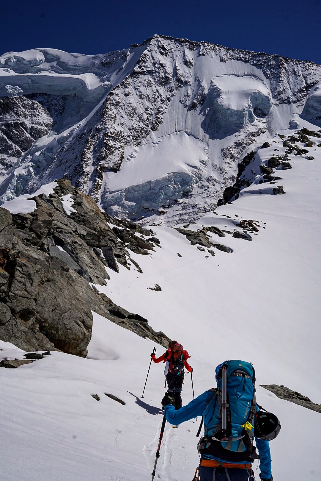 Deux alpinistes progressent à skis au pied des séracs.