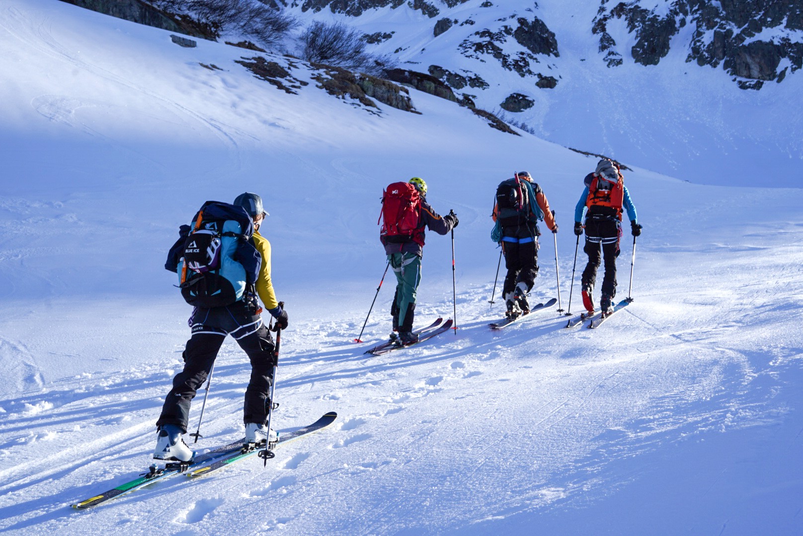 Quatre skieurs de randonnée en montée dans la lumière du matin, Dammastock