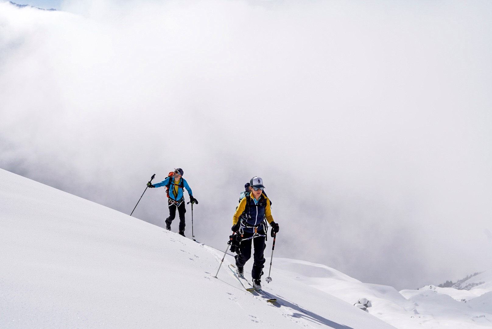 Deux skieurs de randonnée en montée dans la neige, au milieu des nuages, traversée du Dammastock