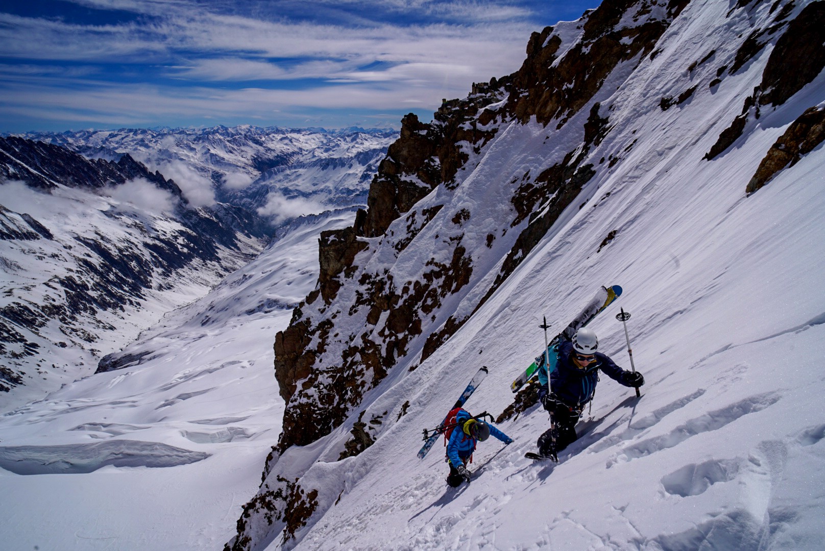 Montée à pied dans une pente raide de neige et de roche, vallée glaciaire en contrebas, Dammastock